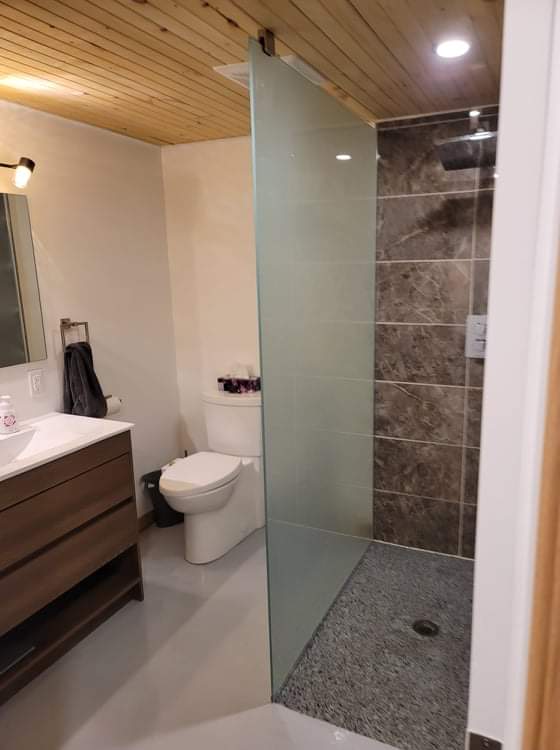 Une salle de bain avec WC, lavabo et douche à l'italienne.