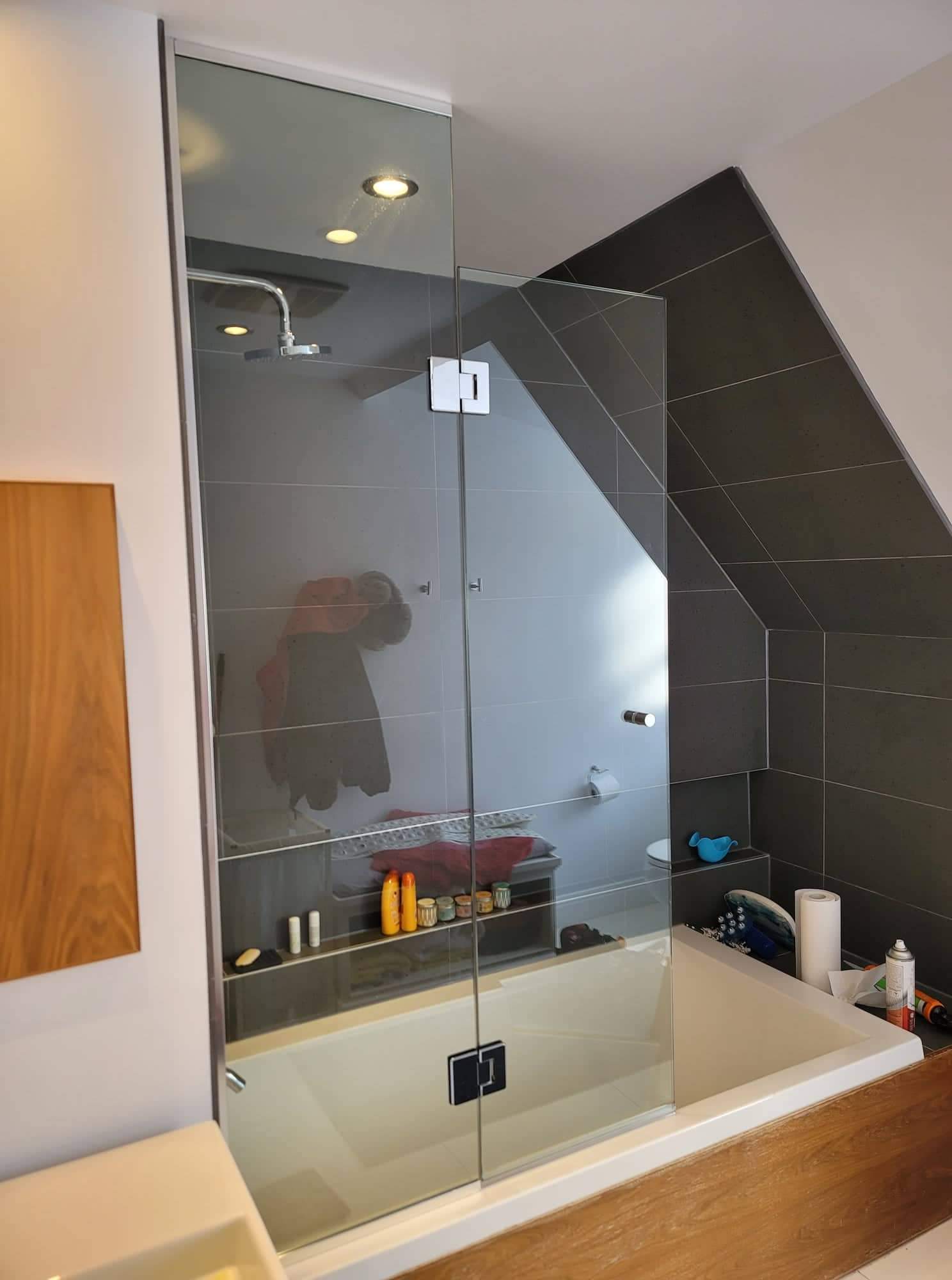 Une salle de bain avec une baignoire et une douche avec une porte vitrée.