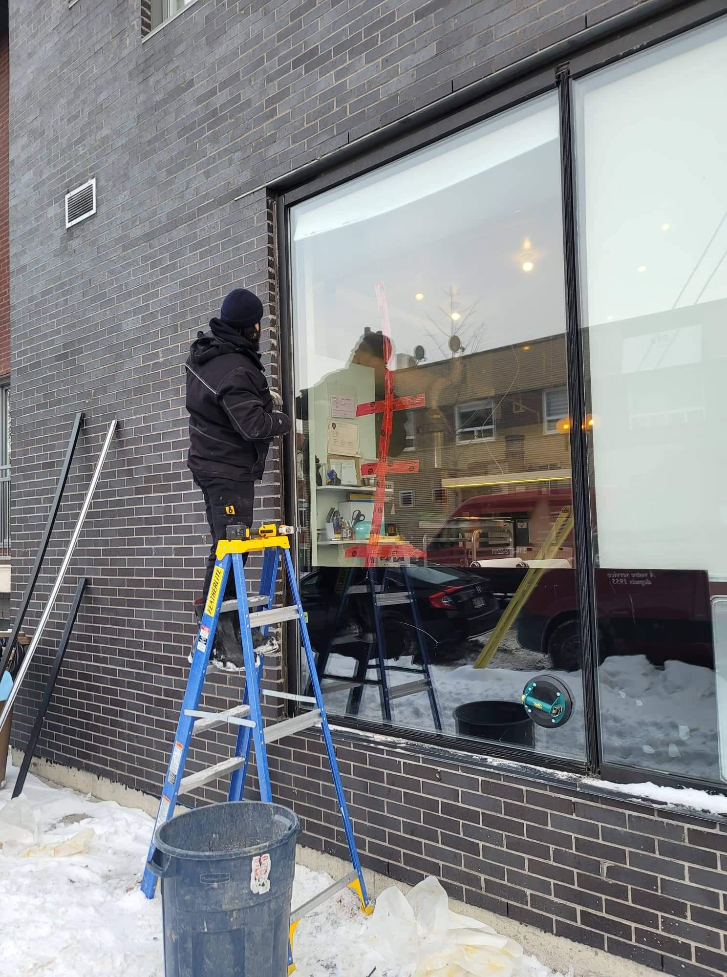 Un homme debout sur une échelle à l'extérieur d'un bâtiment