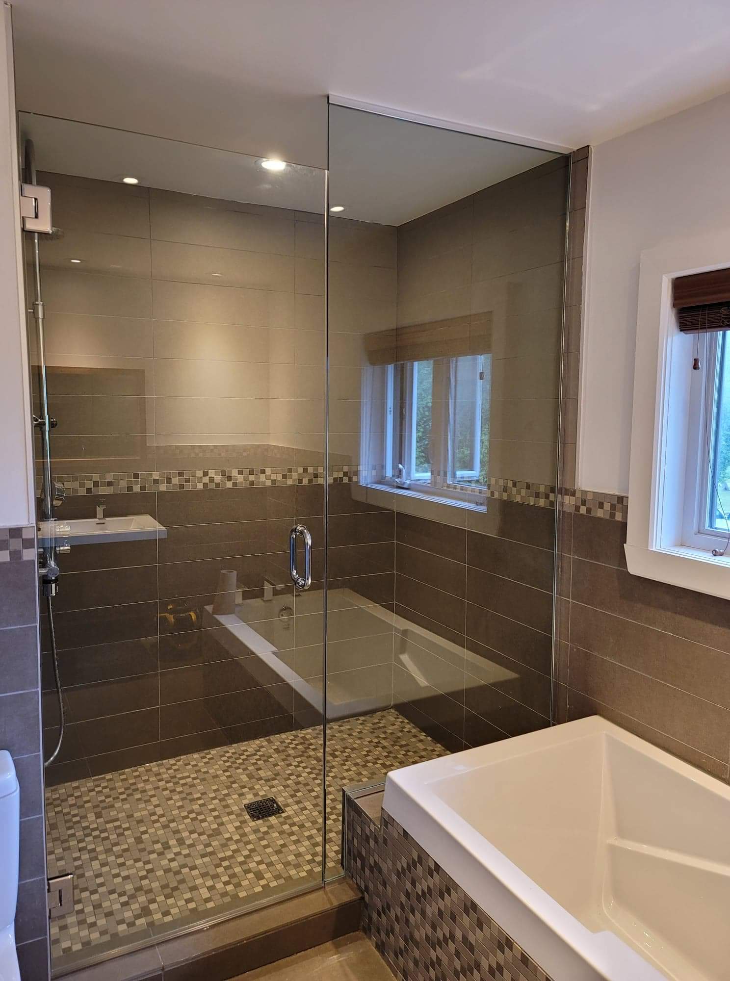 Une salle de bain avec baignoire, douche et fenêtre.