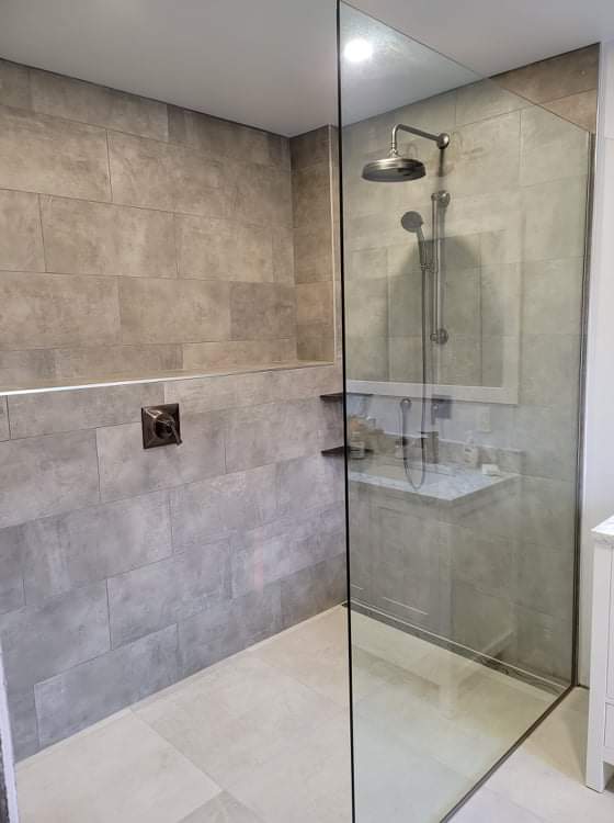 Une salle de bain avec une douche à l'italienne et un lavabo.