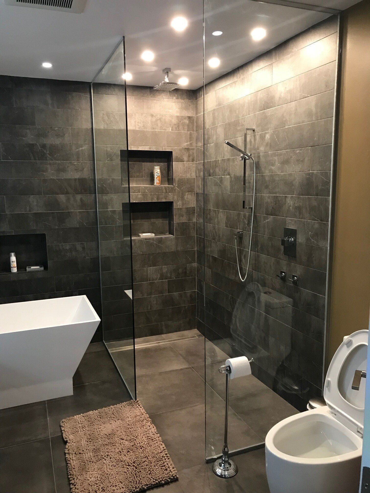 Une salle de bain avec douche à l'italienne, WC et baignoire.