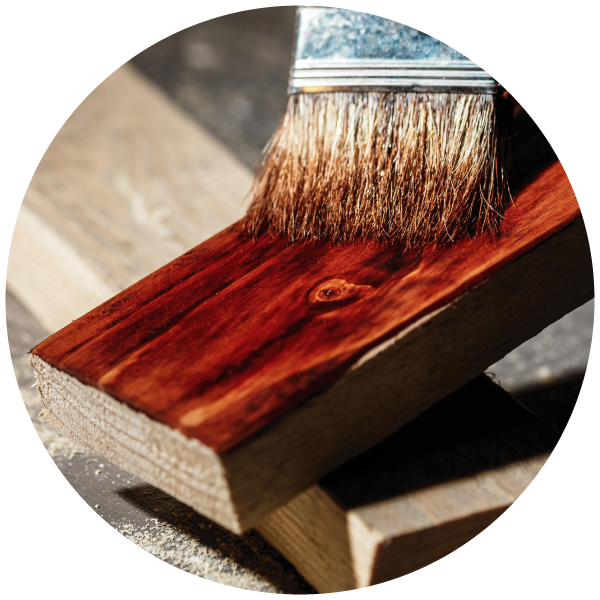 正在用刷子給一塊木頭塗漆