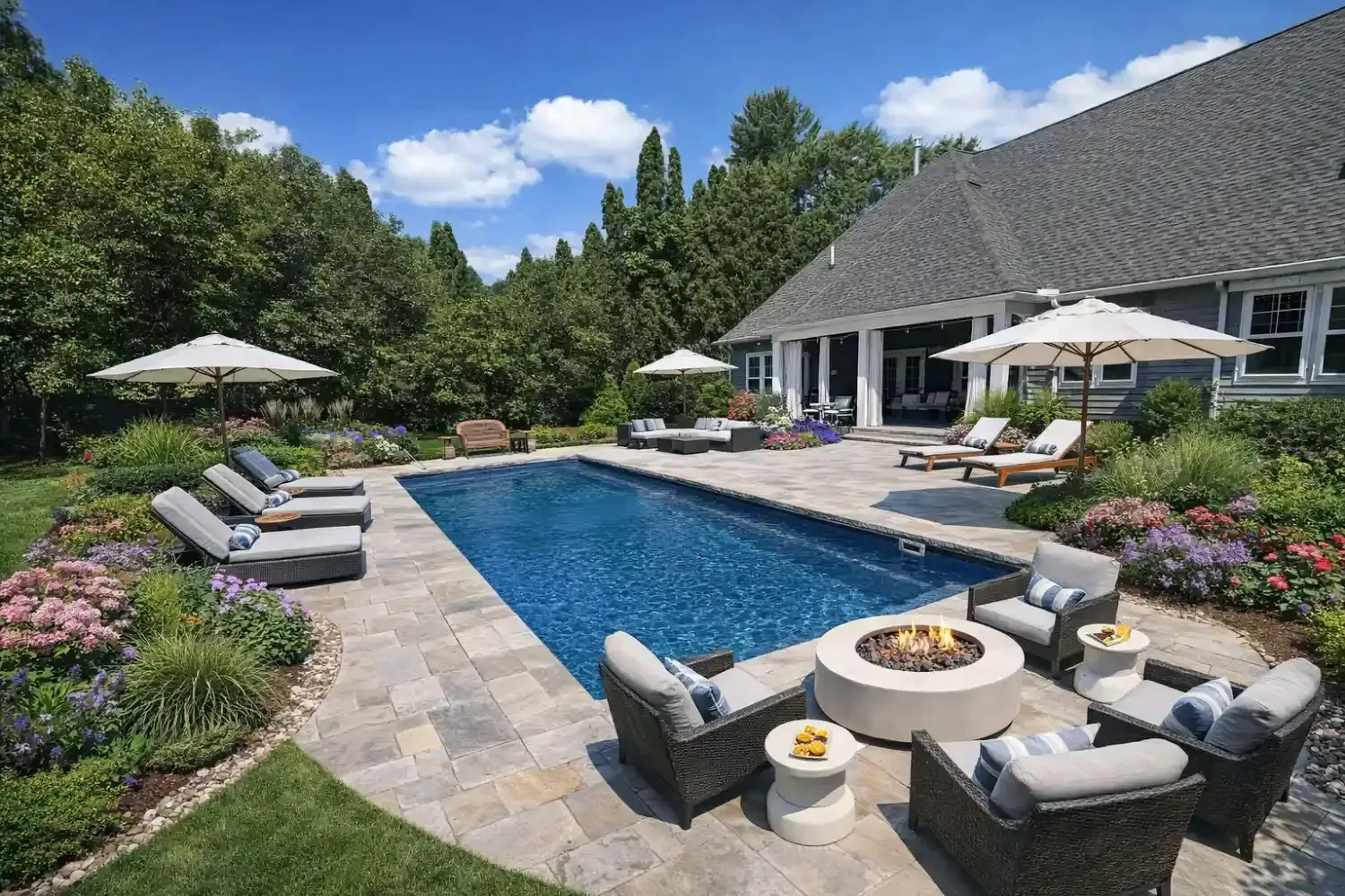 Patio with rectangular pool, paving stones, chairs, and garden features.