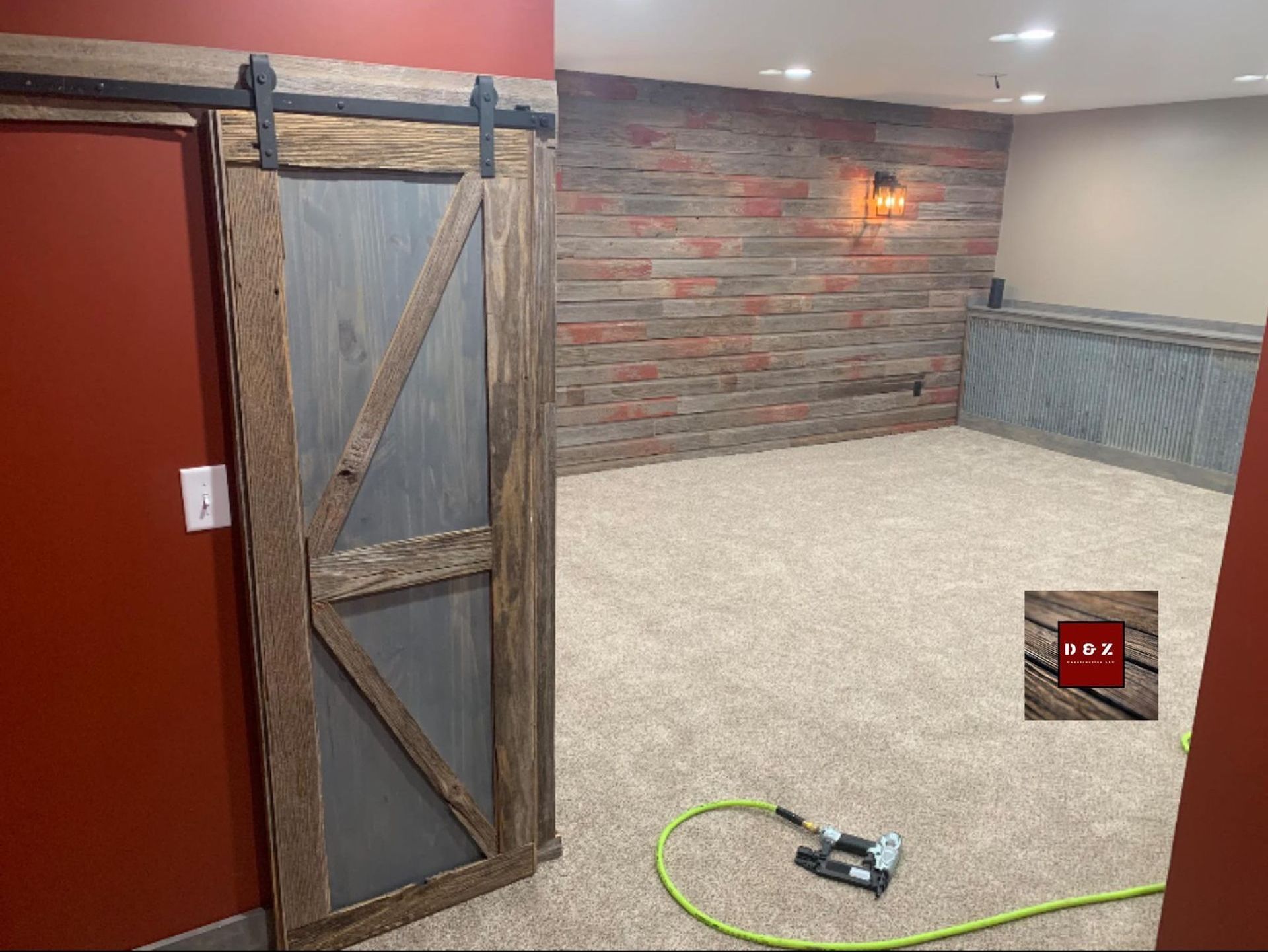 A room with a sliding barn door and a brick wall.