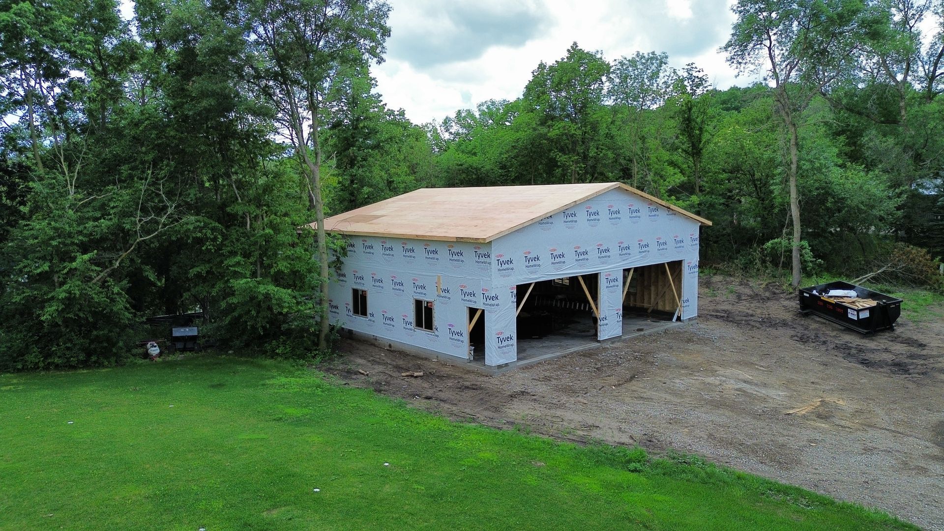 A garage is being built in the middle of a grassy field.