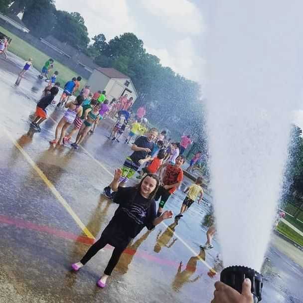 A group of people are standing in front of a water fountain