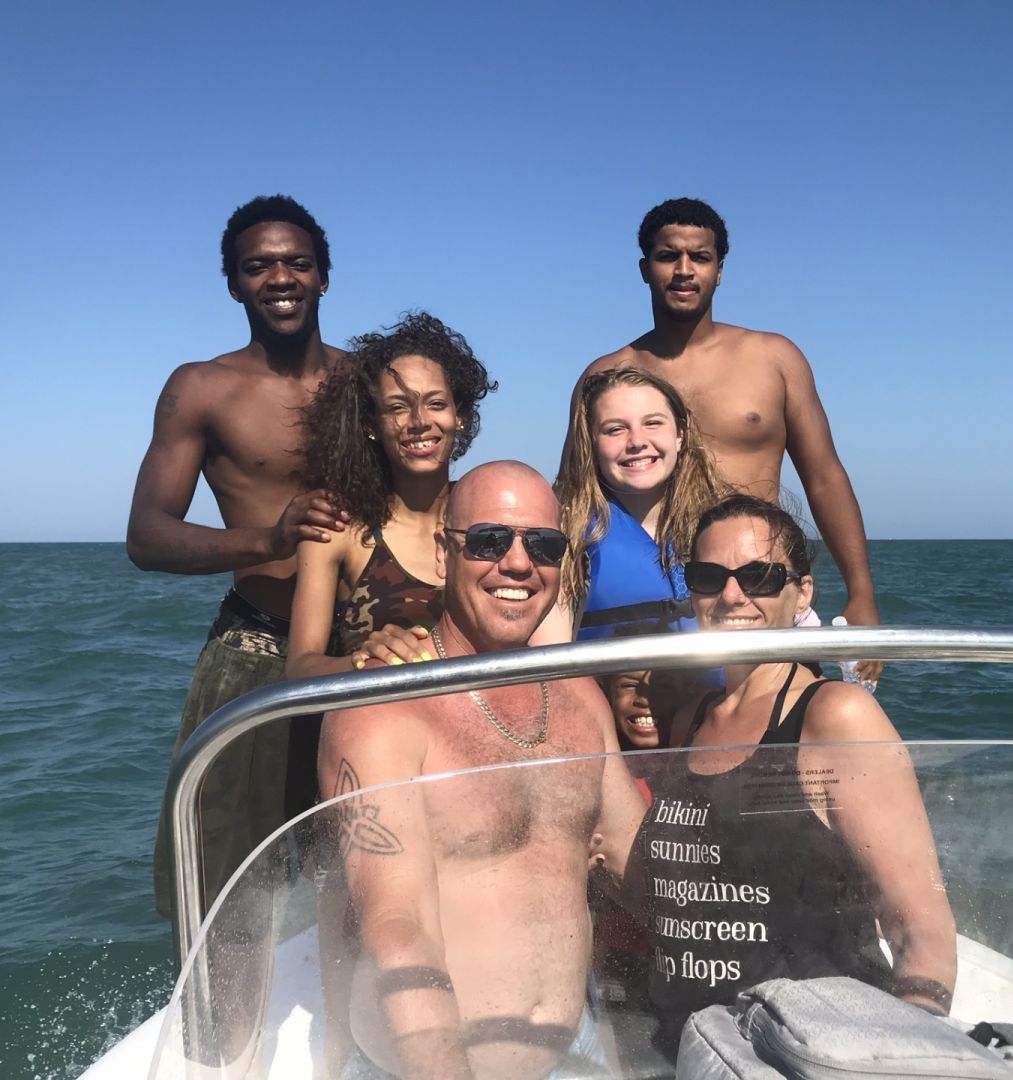 A group of people are posing for a picture on a boat in the ocean
