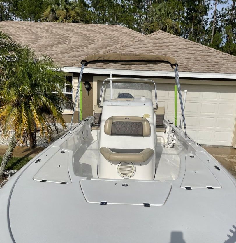 A white boat is parked in front of a house