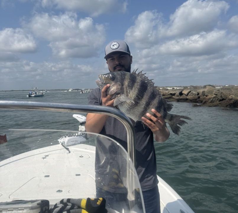 A man on a boat holding a large fish