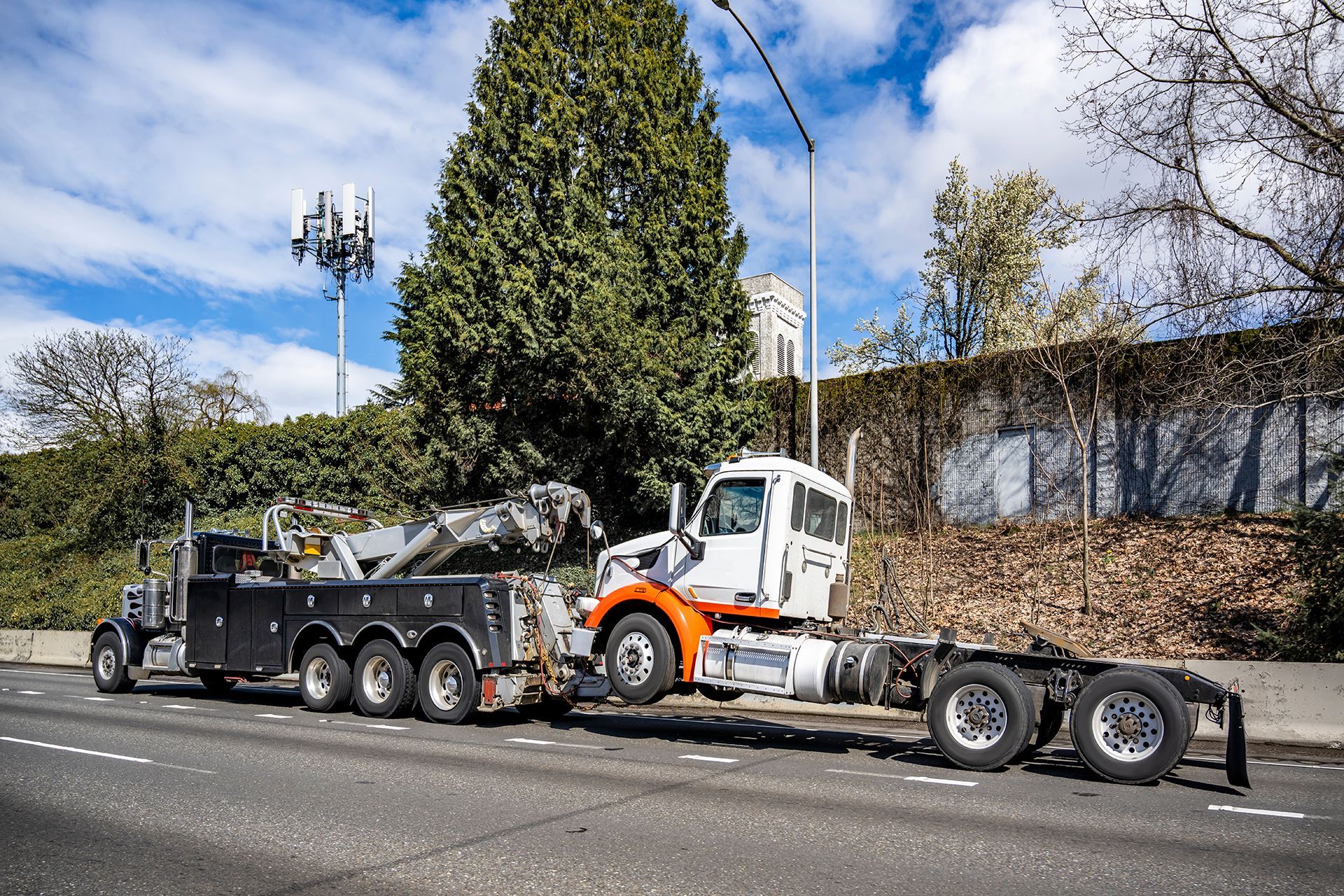 A white van is being towed by a tow truck.