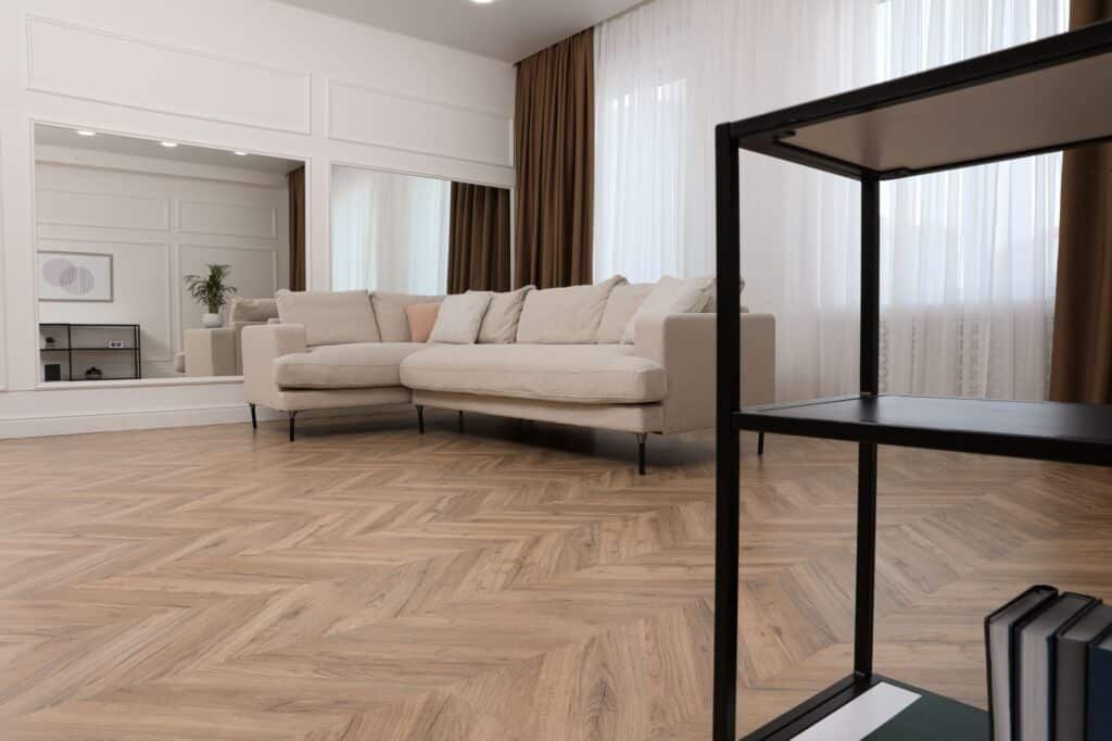 A modern living room with herringbone wood flooring