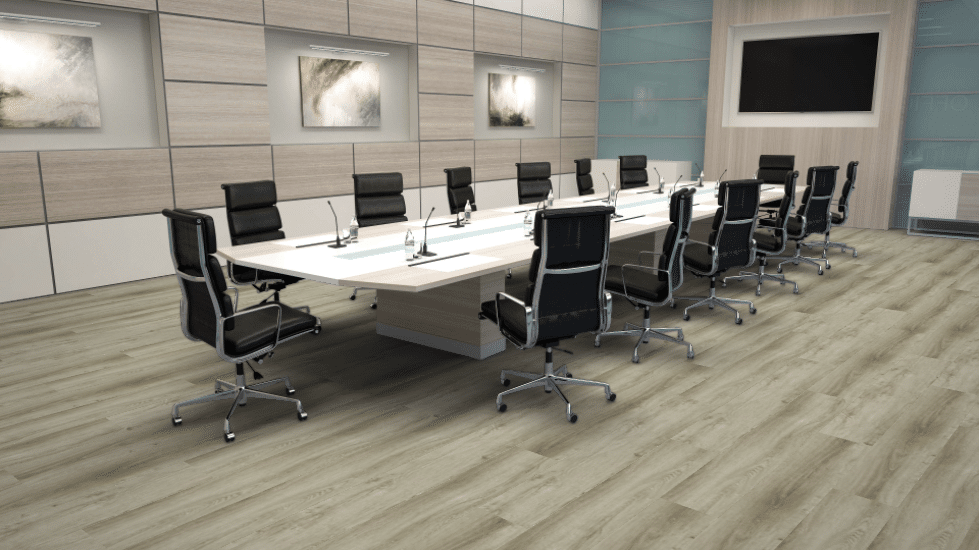 A modern, empty conference room with a long table, ergonomic black chairs, and light-toned wood flooring and wall panels.