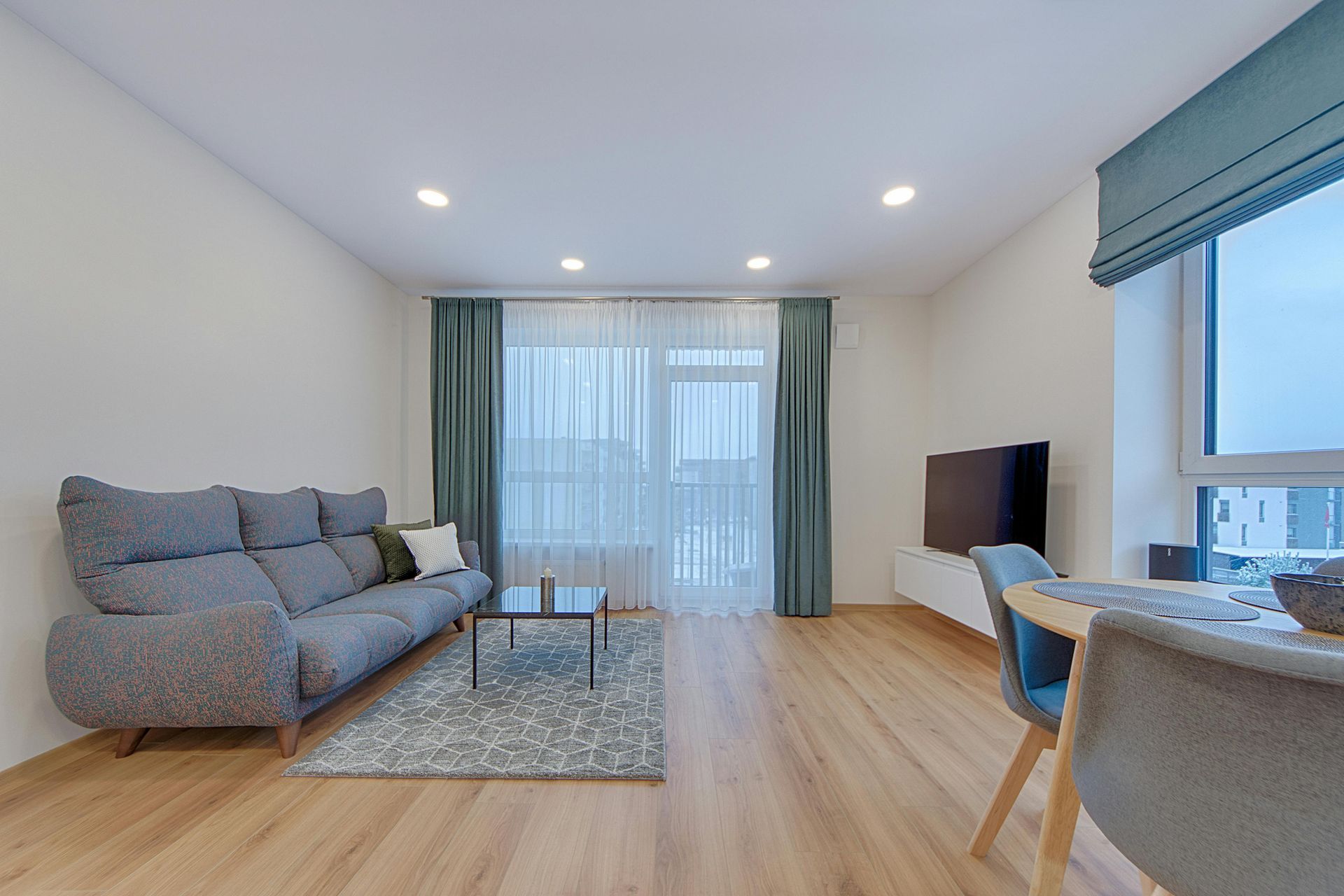 A yellow wet floor sign and a janitorial cleaning cart in a bright, modern office hallway.
