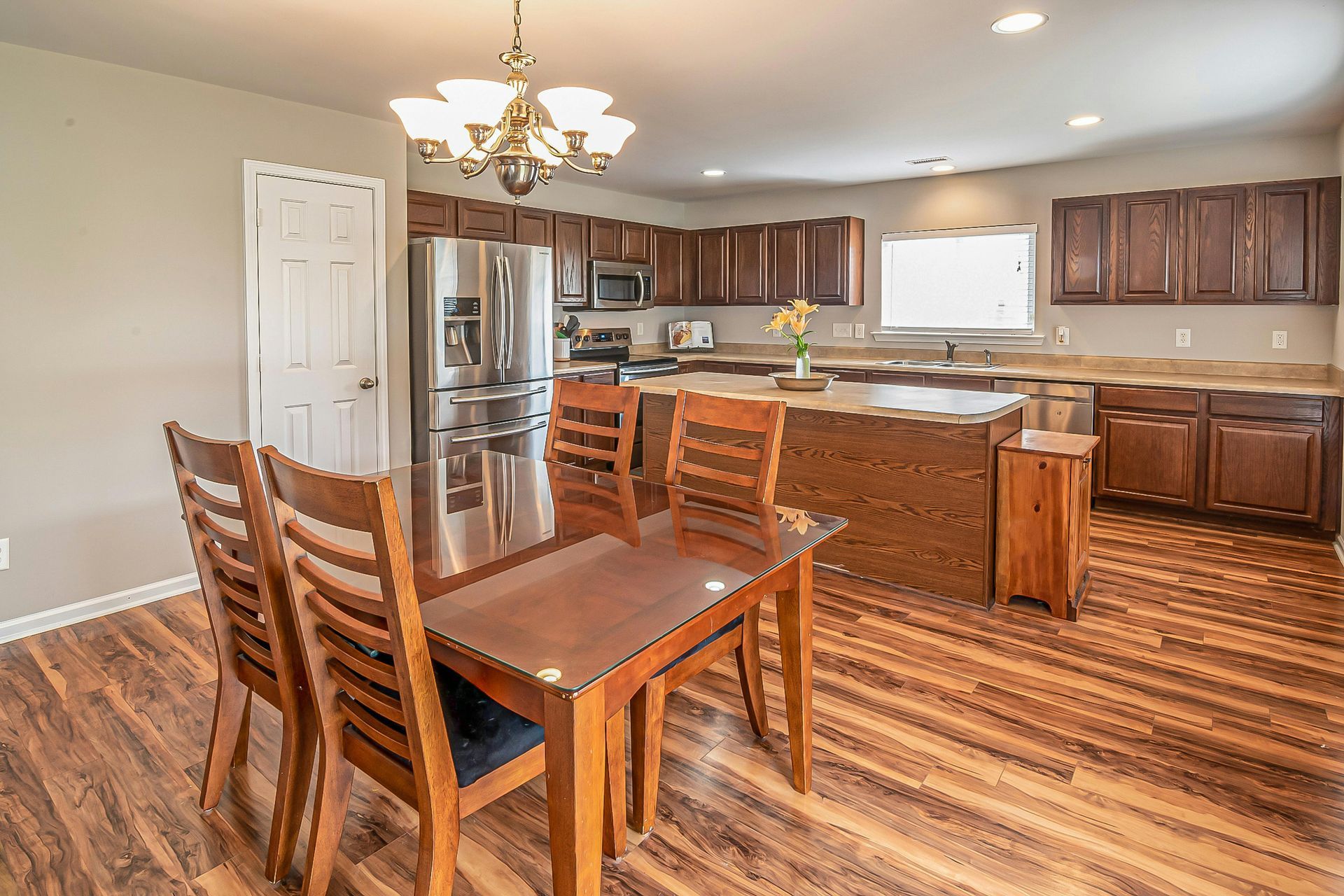 A yellow wet floor sign and a janitorial cleaning cart in a bright, modern office hallway.