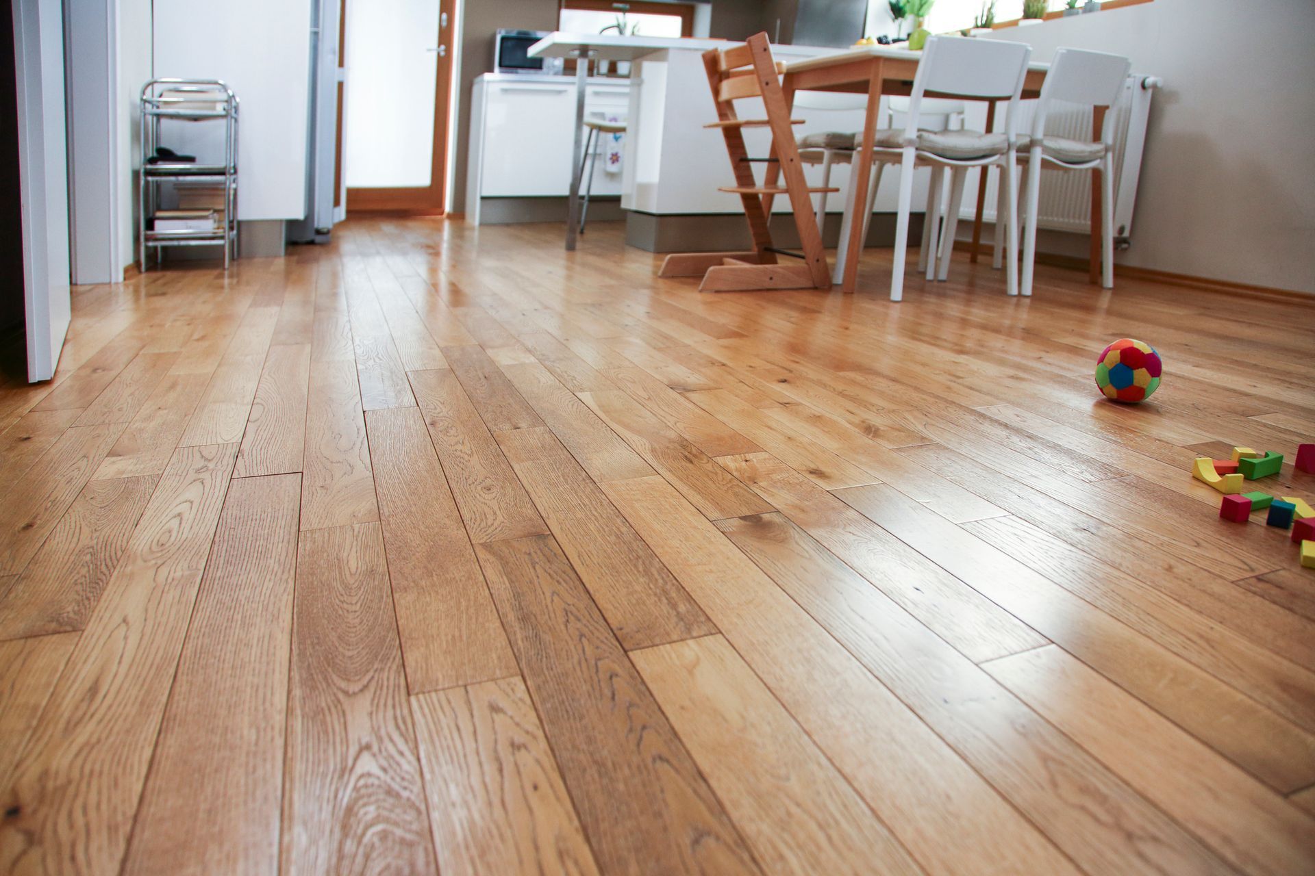 A wooden floor in a kitchen with a table and chairs