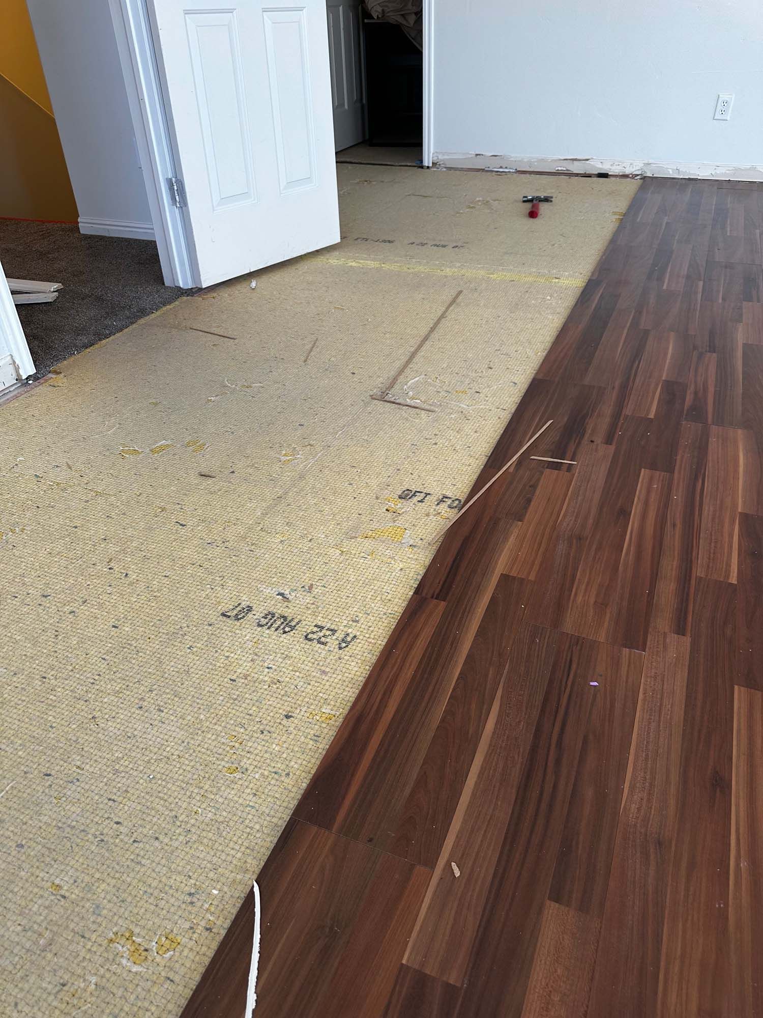 A room with a wooden floor and a carpeted floor.