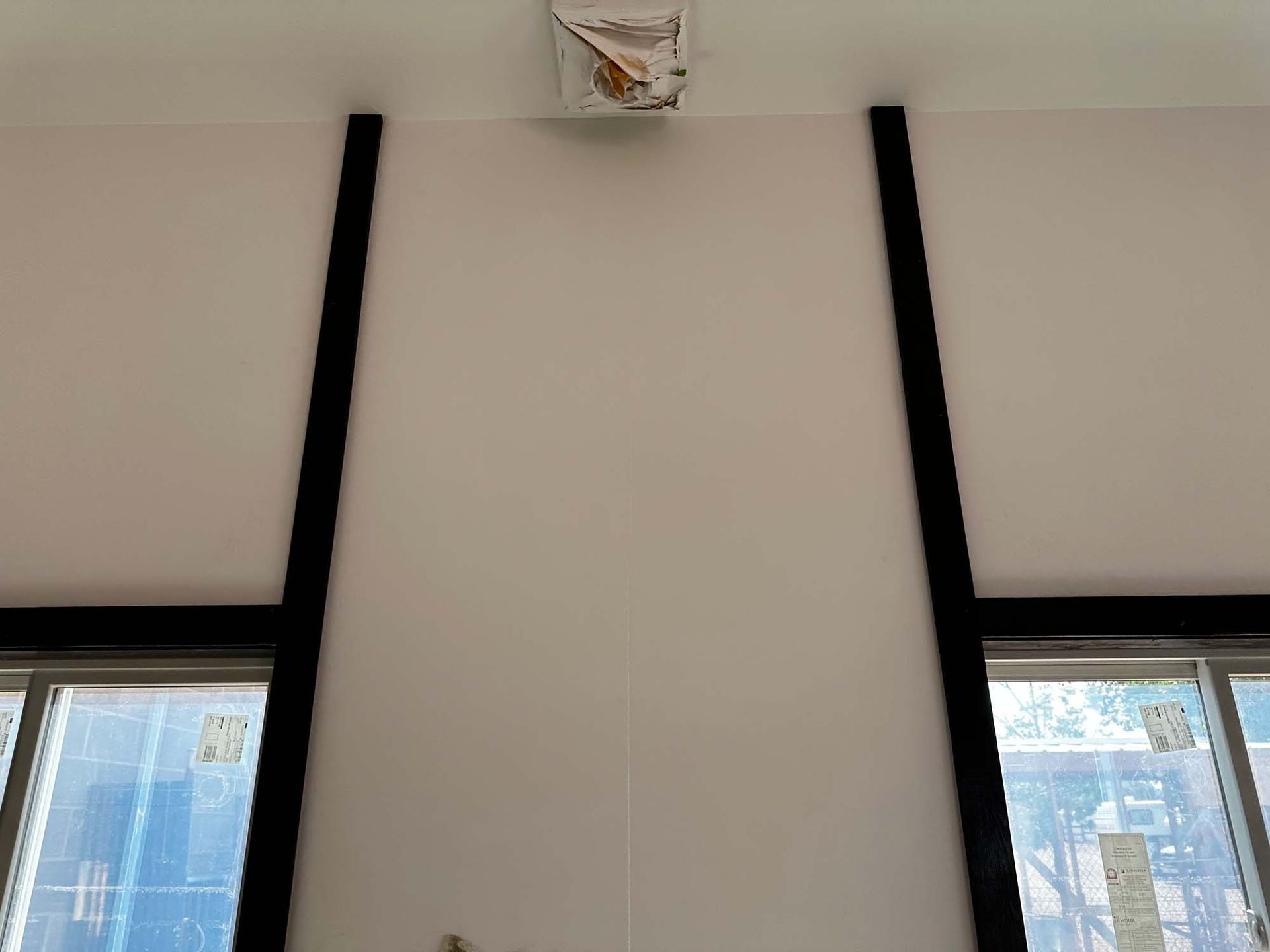 A white wall with black trim and two windows