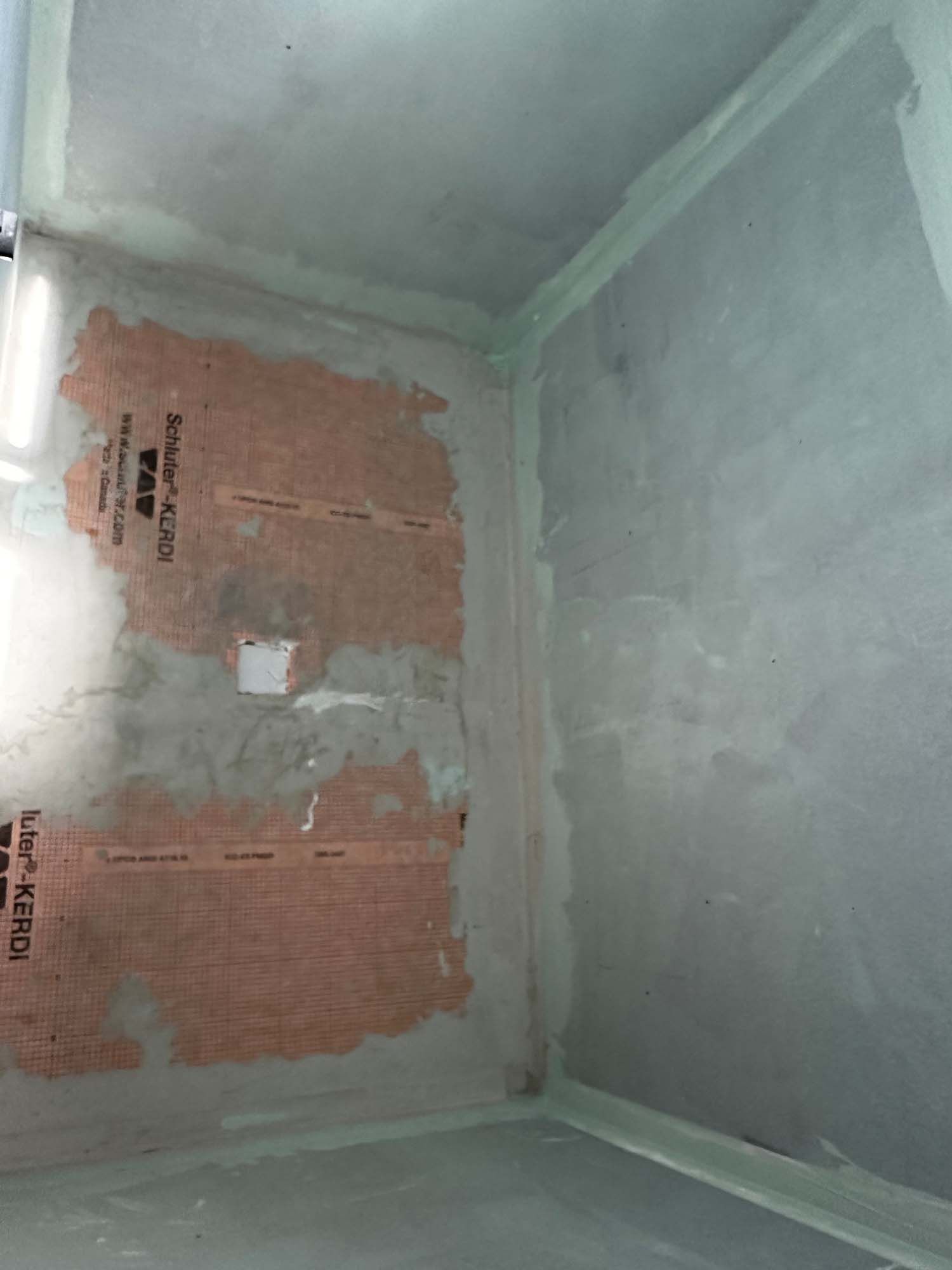 A corner of a room with a piece of paper on the wall.
