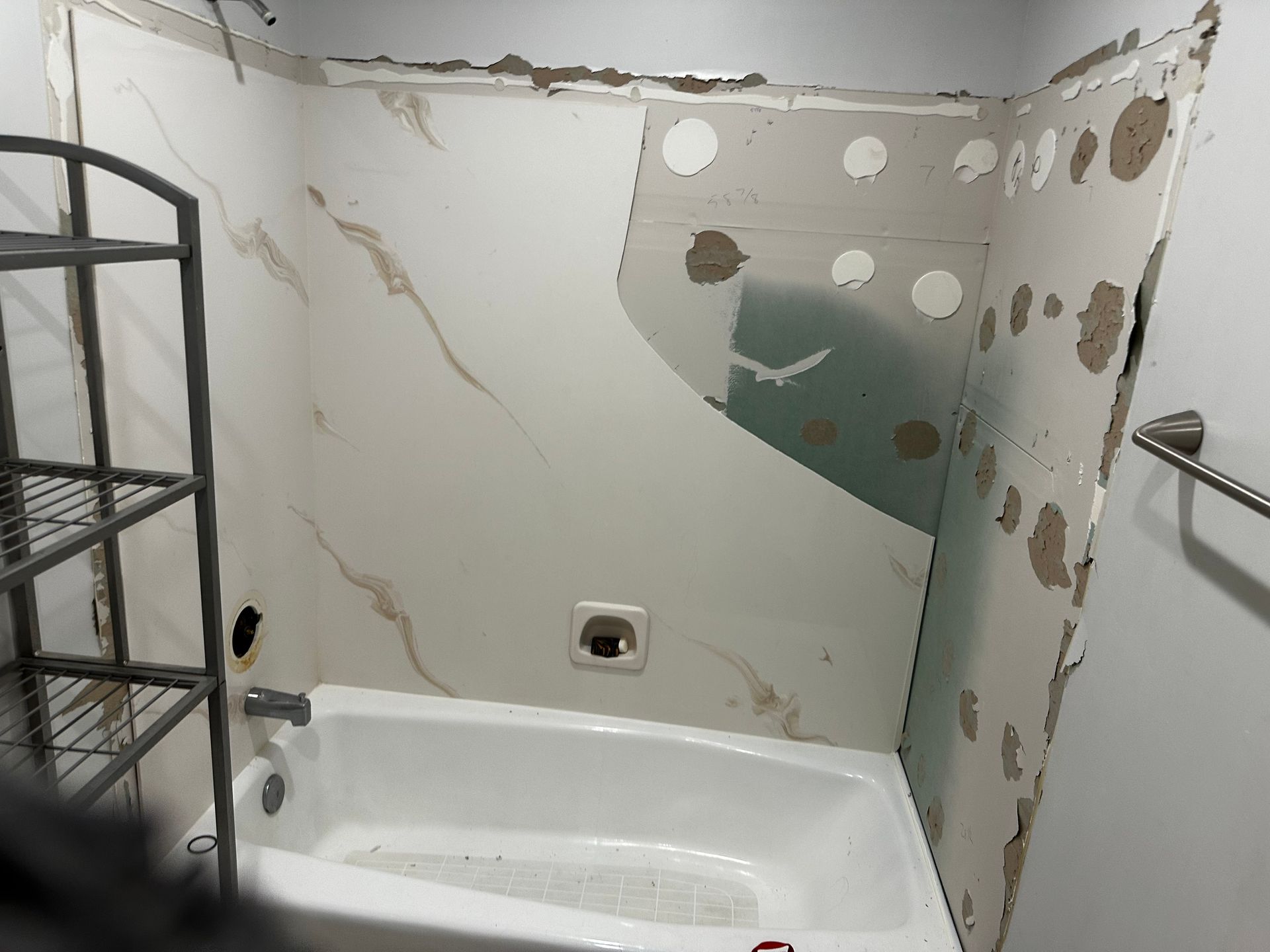 A bathroom with a bathtub and a shelf.