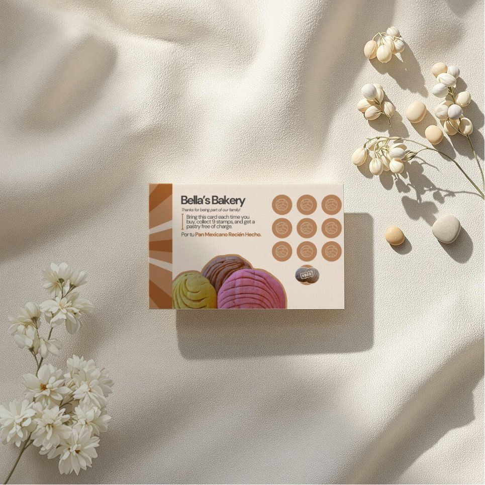 Business card for Bella's Bakery with cookies and ice cream flavors, on a cream fabric with flowers.