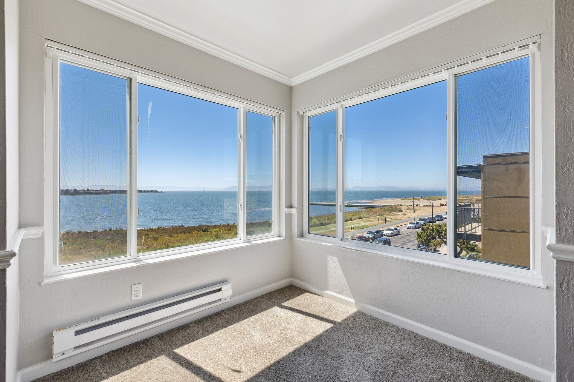 Corner living area with large bay windows and an ocean view.