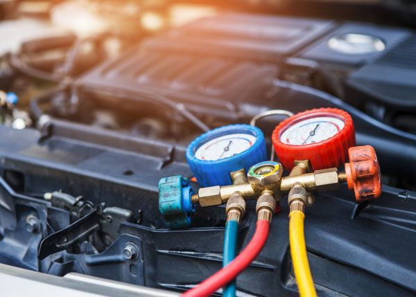 A close up of a car engine with gauges attached to it.