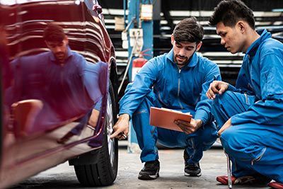 A group of mechanics are working on a car in a garage.