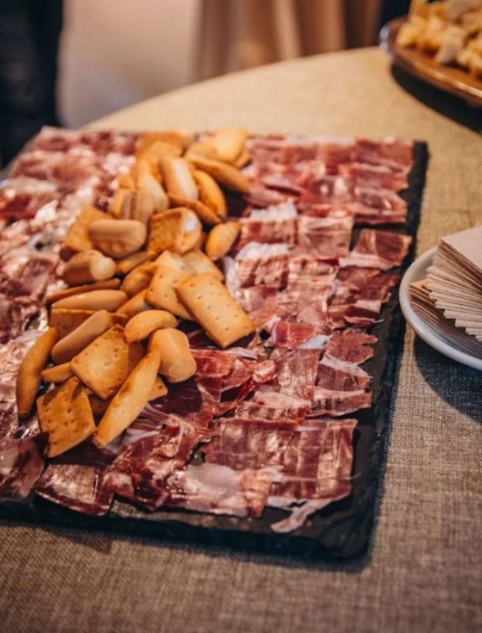 Charcuterie board with sliced meats and crackers on a table.