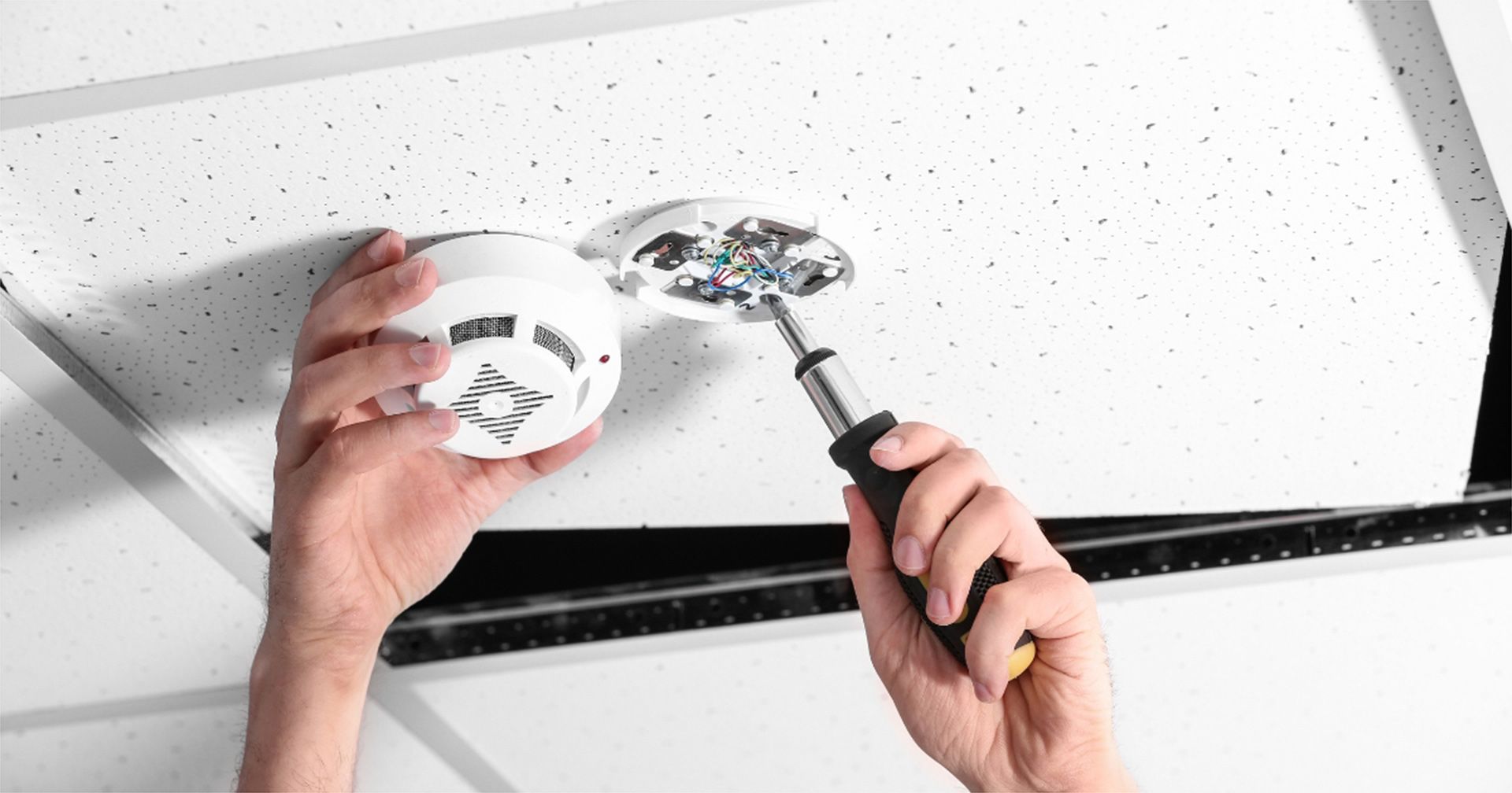 Technician Installing Ceiling Mounted Smoke Alarm Caloundra