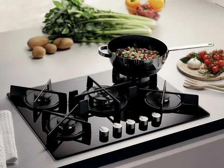 A pot of food is cooking on a black stove top