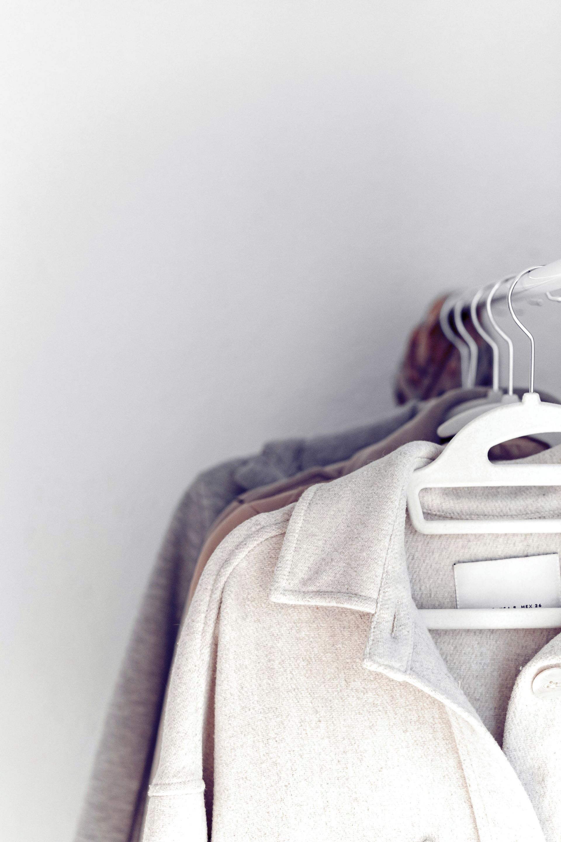 woollen coats on felt coat hangers hanging from a clothes rack