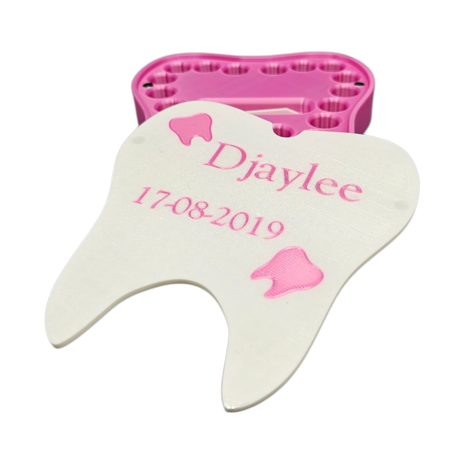 Een wit, tandvormig bewaardoosje met roze accenten, gepersonaliseerd met de naam 