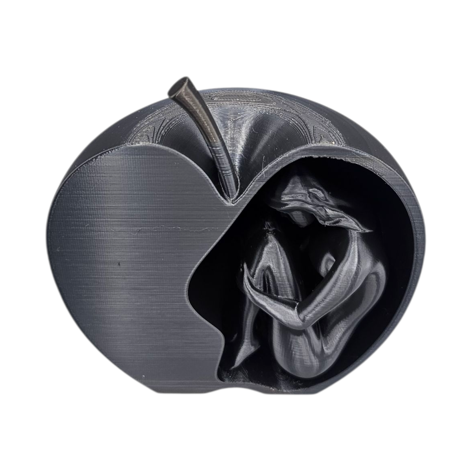 Een sculptuur van een vrouw die opgerold in een metalen appel ligt, rustend op een houten ondergrond.