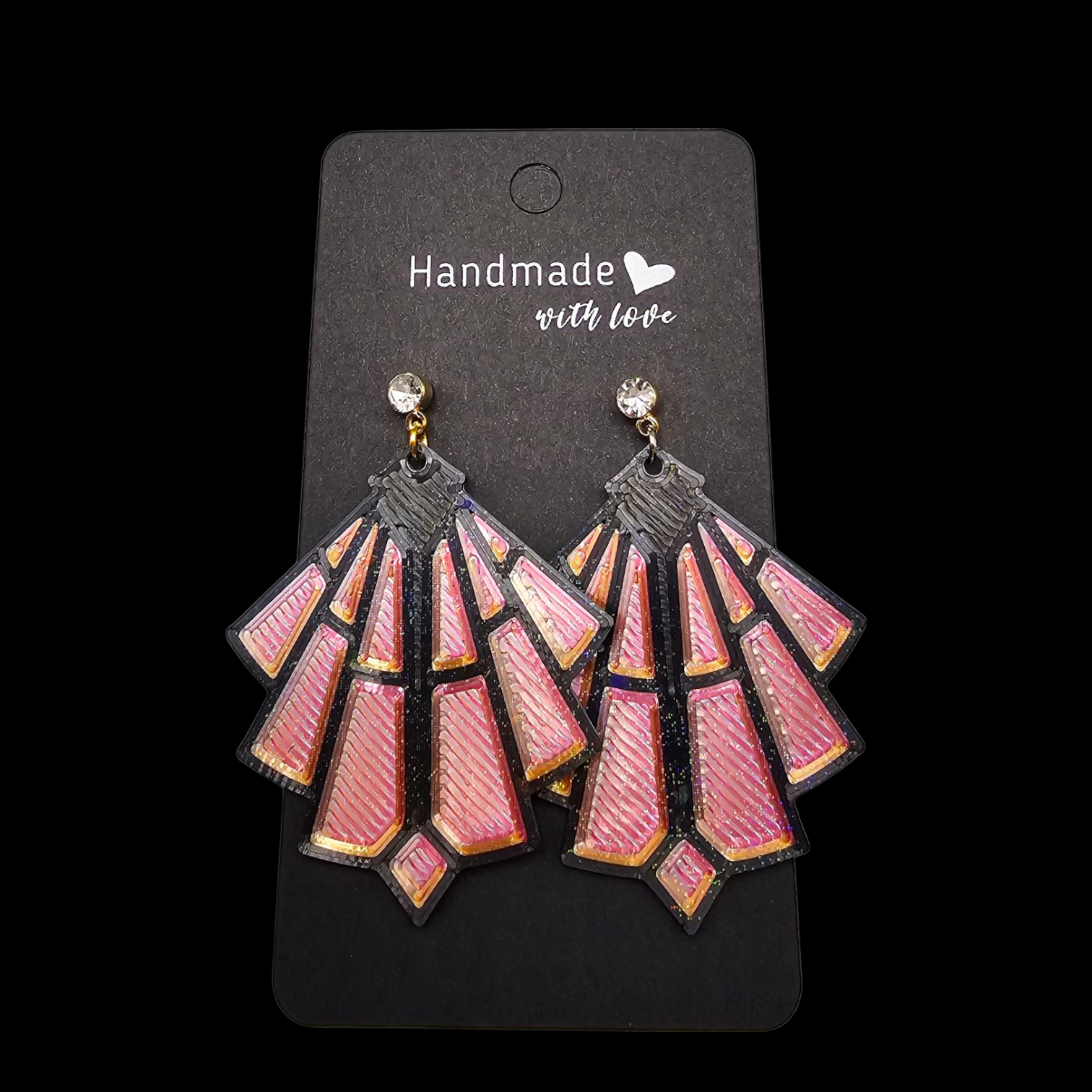 Roze art deco oorbellen op een zwart presentatiekaartje, met een klein edelsteentje aan de bovenkant.