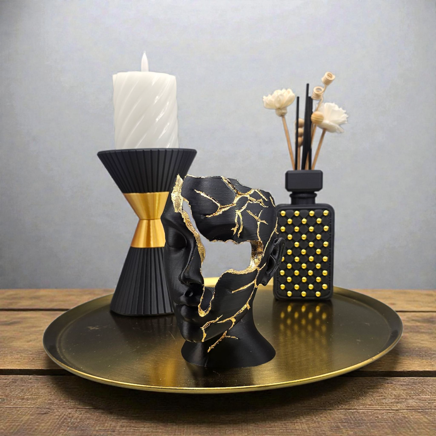 Zwarte en gouden zandlopervormige vaas, 17,5 cm hoog, met een klein roze flesje op een marmeren voetstuk.