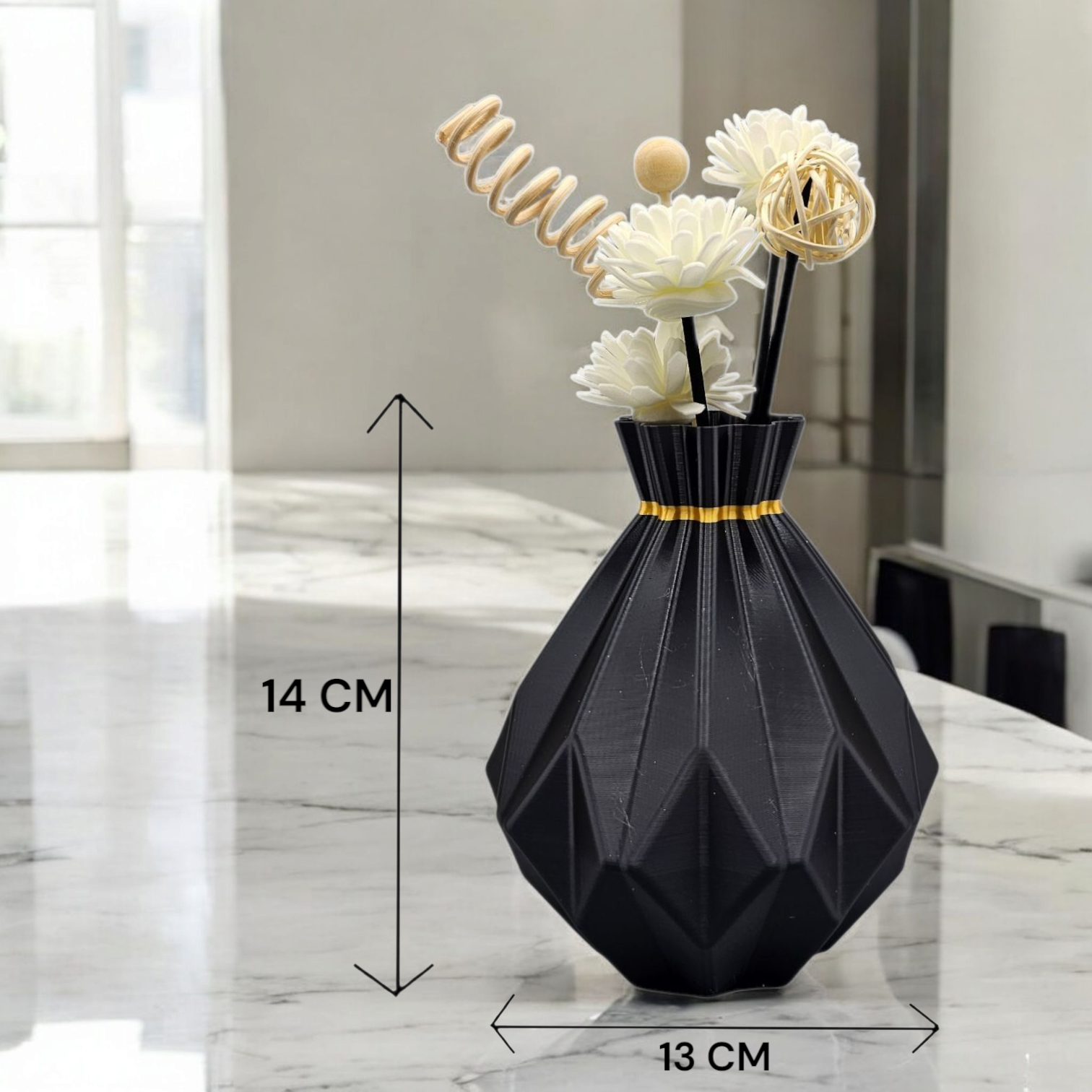 Zwarte geometrische vaas met gedroogde bloemen, 14 cm hoog en 13 cm breed, op een marmeren ondergrond.