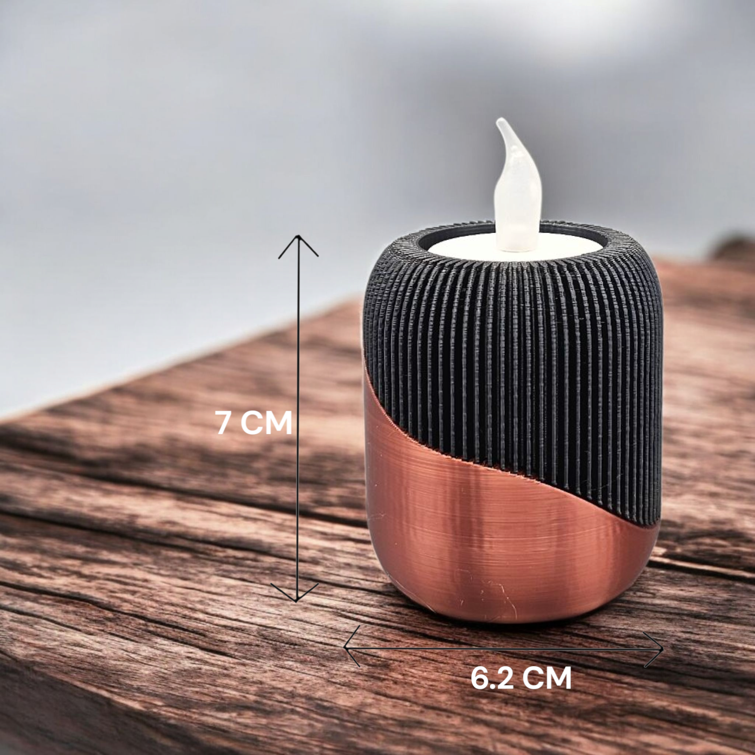 Zwarte en koperkleurige decoratieve objecten op een marmeren tafel: een vaas met pampasgras en twee kandelaars met nepkaarsen.