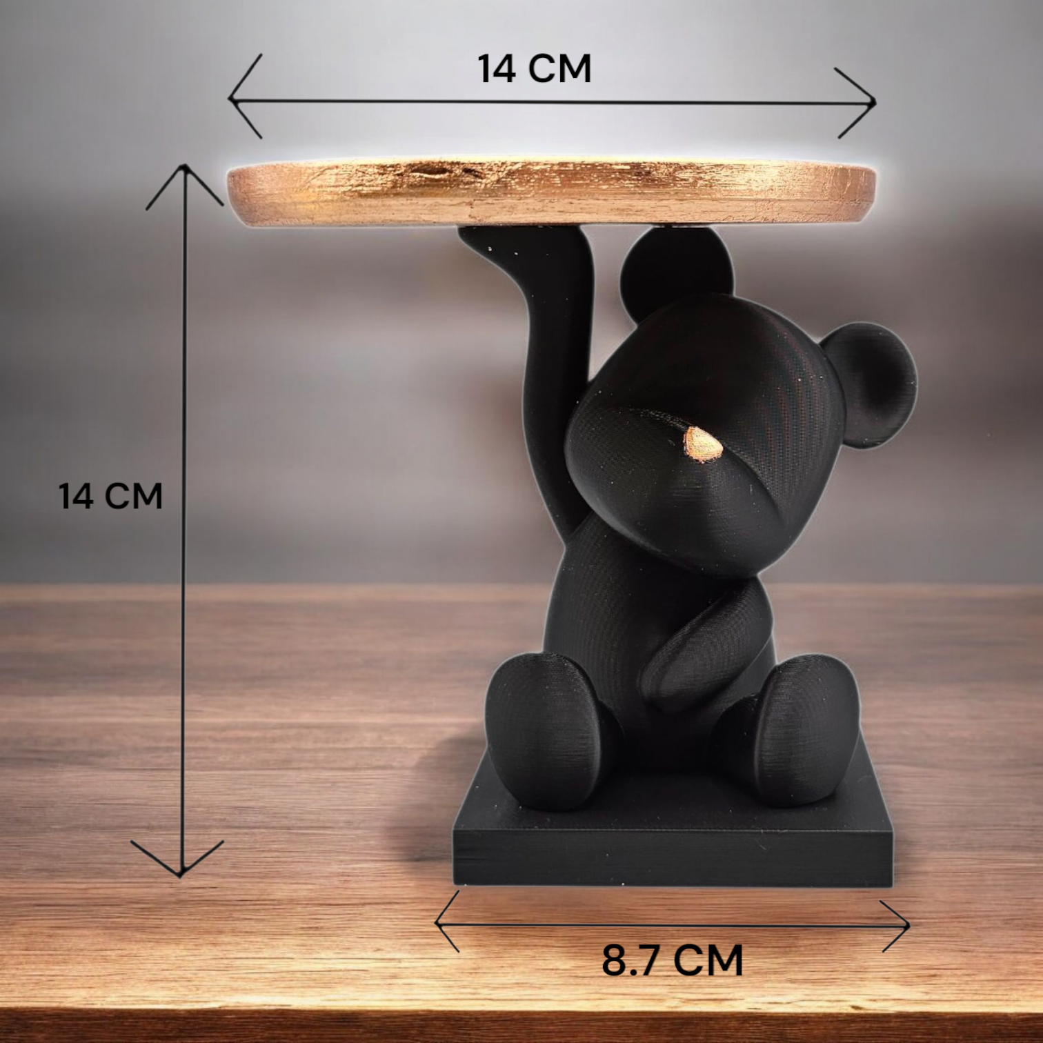Een tafel in de vorm van een zwarte beer met een dienblad waarop een kaars, een rasp en zeep staan; daarnaast een vaas met bloemen.