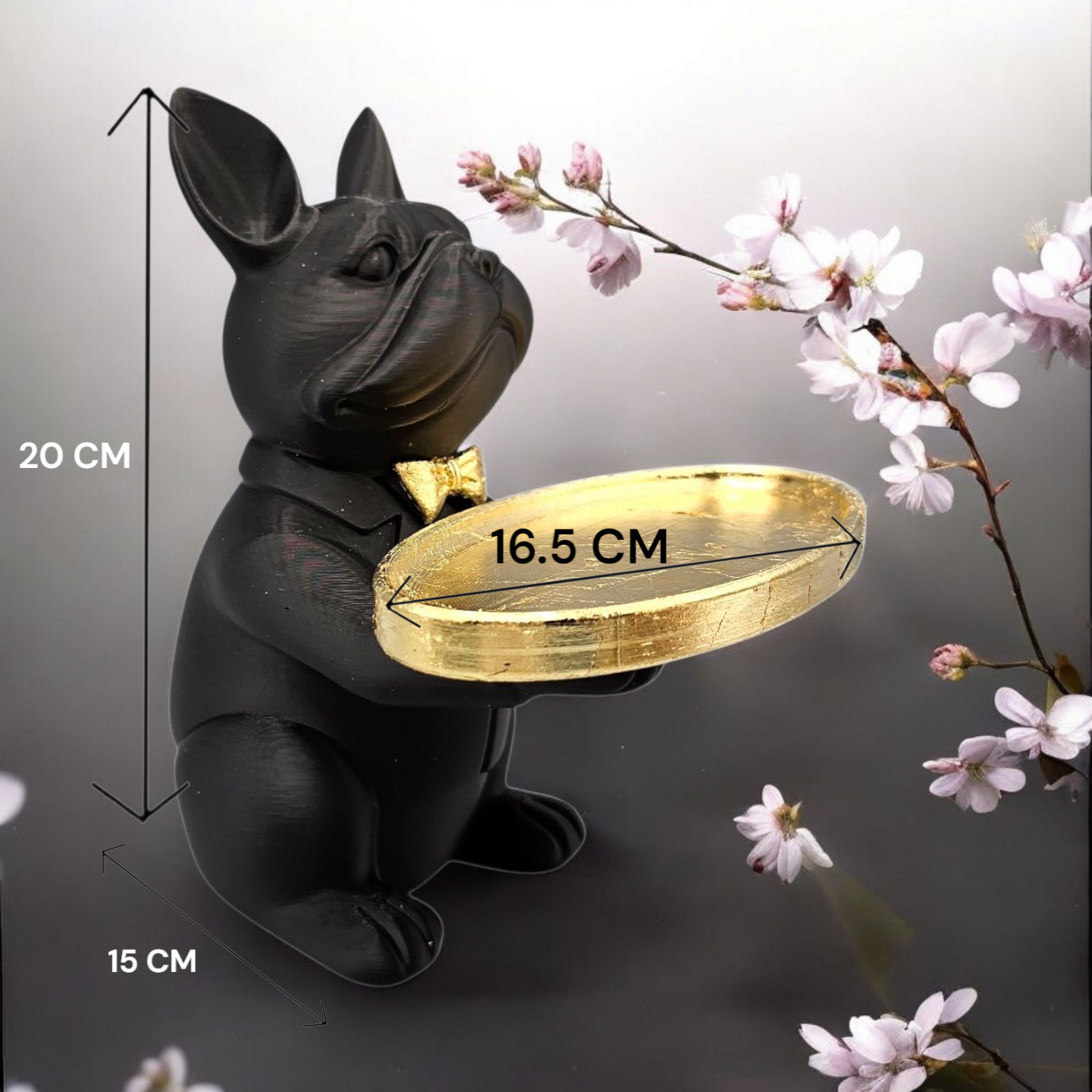 Een beeld van een zwarte bulldog die een gouden dienblad vasthoudt, met op de achtergrond roze kersenbloesemtakken.