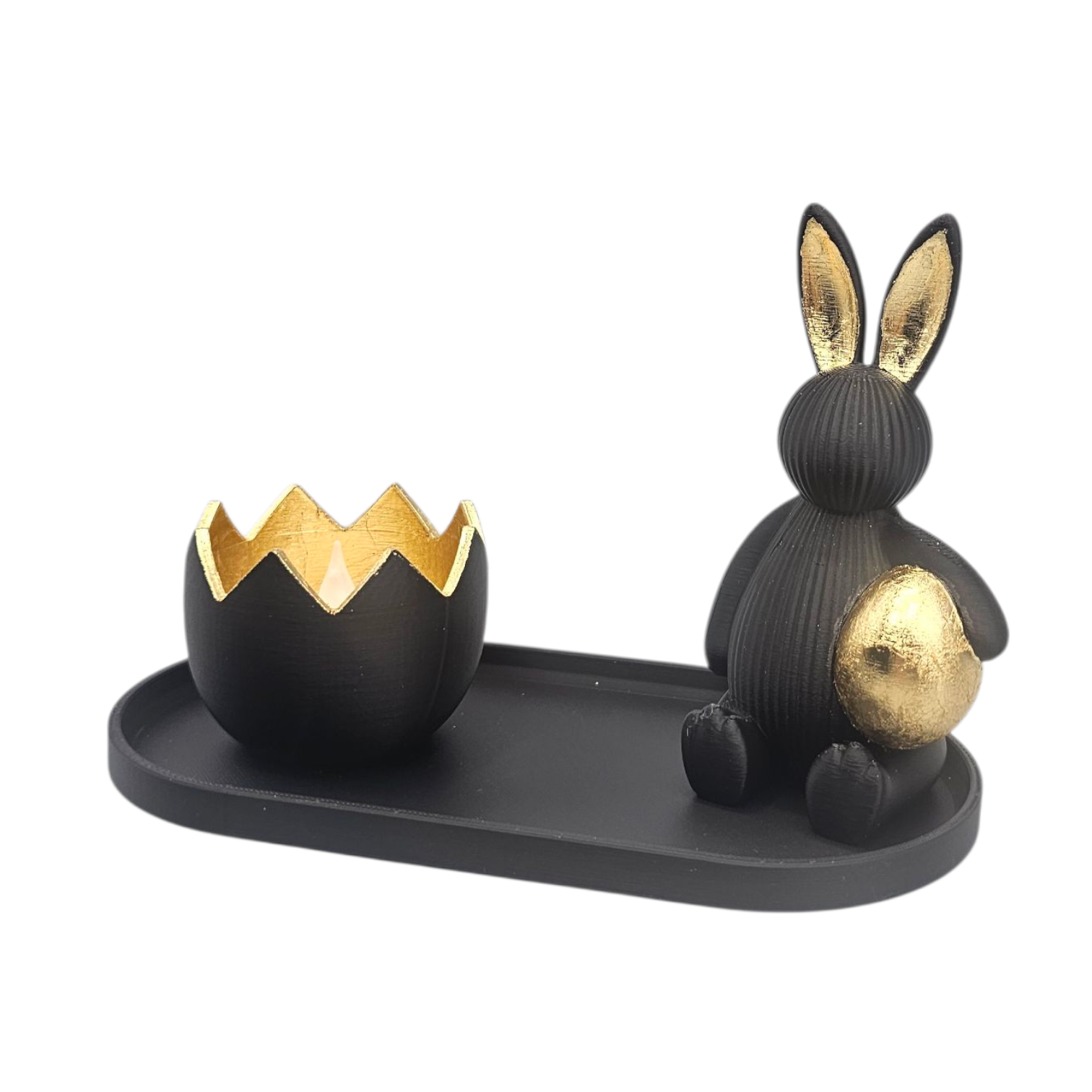 Zwarte paashaas en ei decoratie op een dienblad, met gouden accenten.