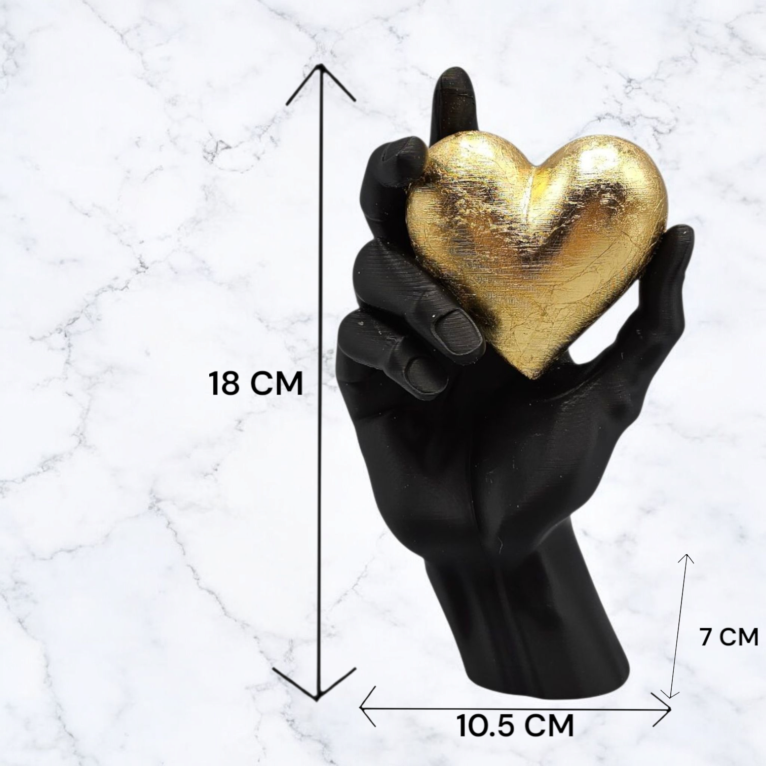 Decoratief tafelarrangement met een zwart-gouden vaas en een hand die een gouden hart vasthoudt.