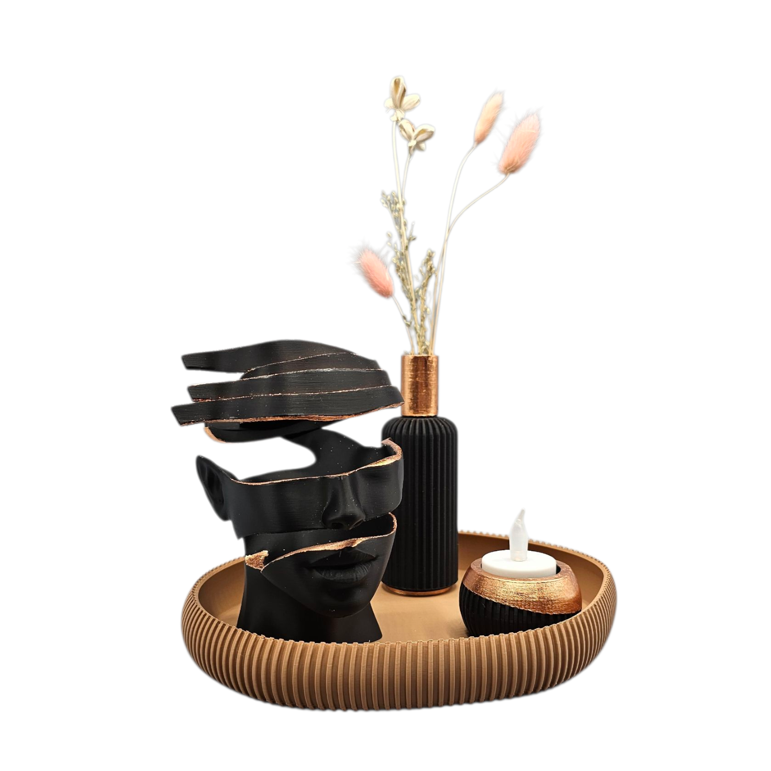 Een decoratieve abstracte sculptuur in zwart en goud, een vaas met gedroogde planten en een kaars op een rond, gestructureerd houten dienblad.