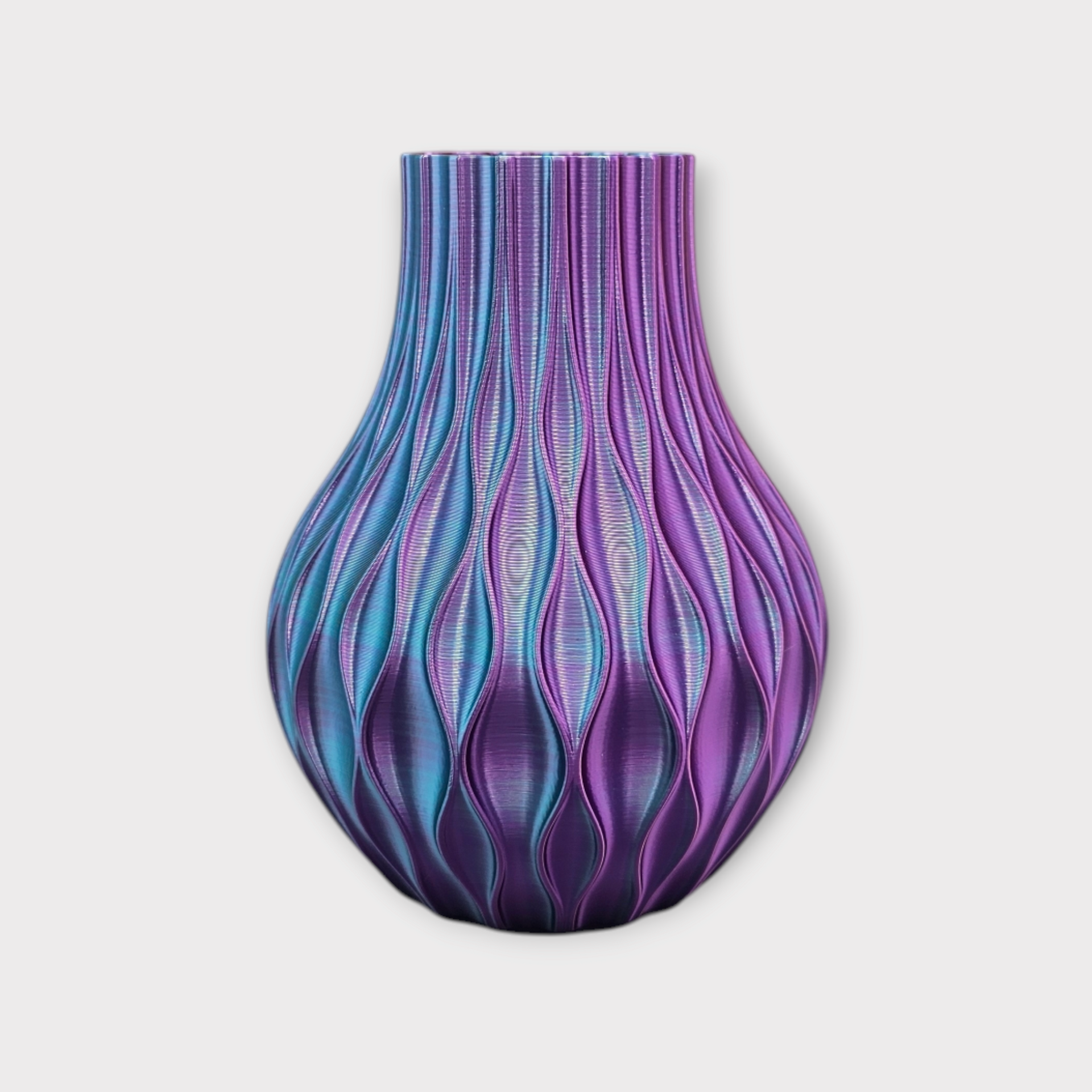 Een 3D-geprinte vaas met een vloeiend, gestructureerd ontwerp. De kleuren variëren tussen blauw en paars.