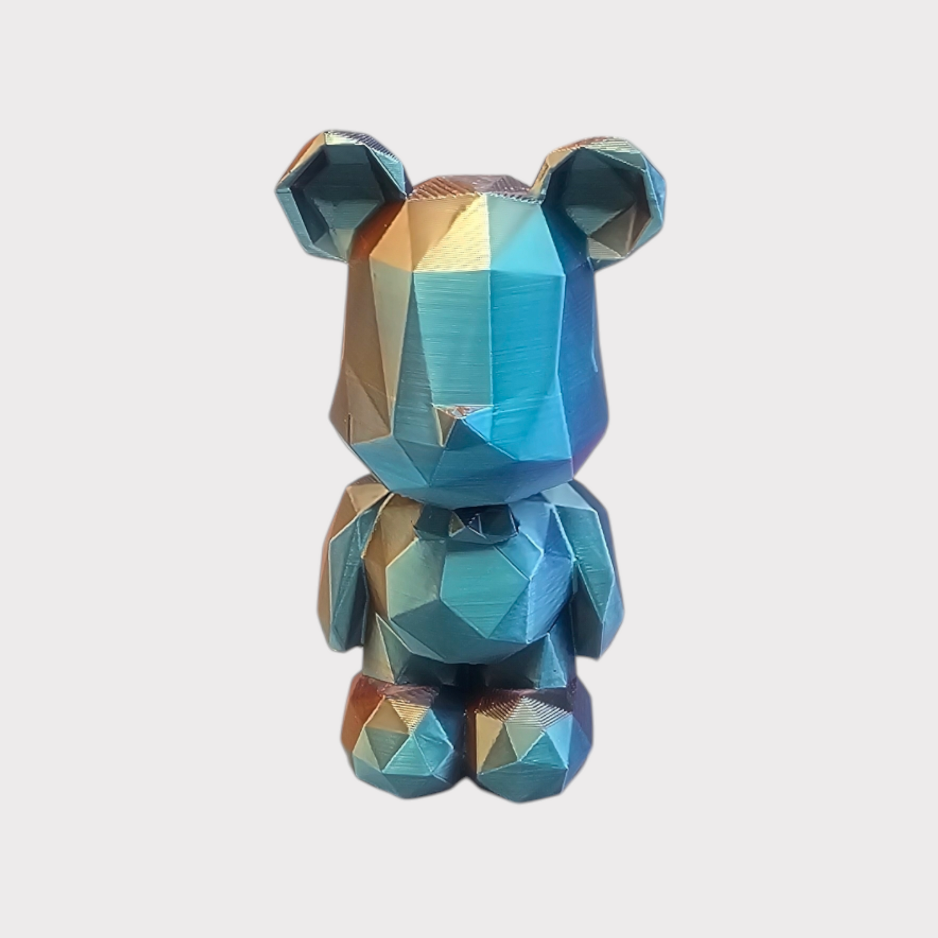 Geometrische berenfiguur met iriserende blauwe en bronzen kleuren.