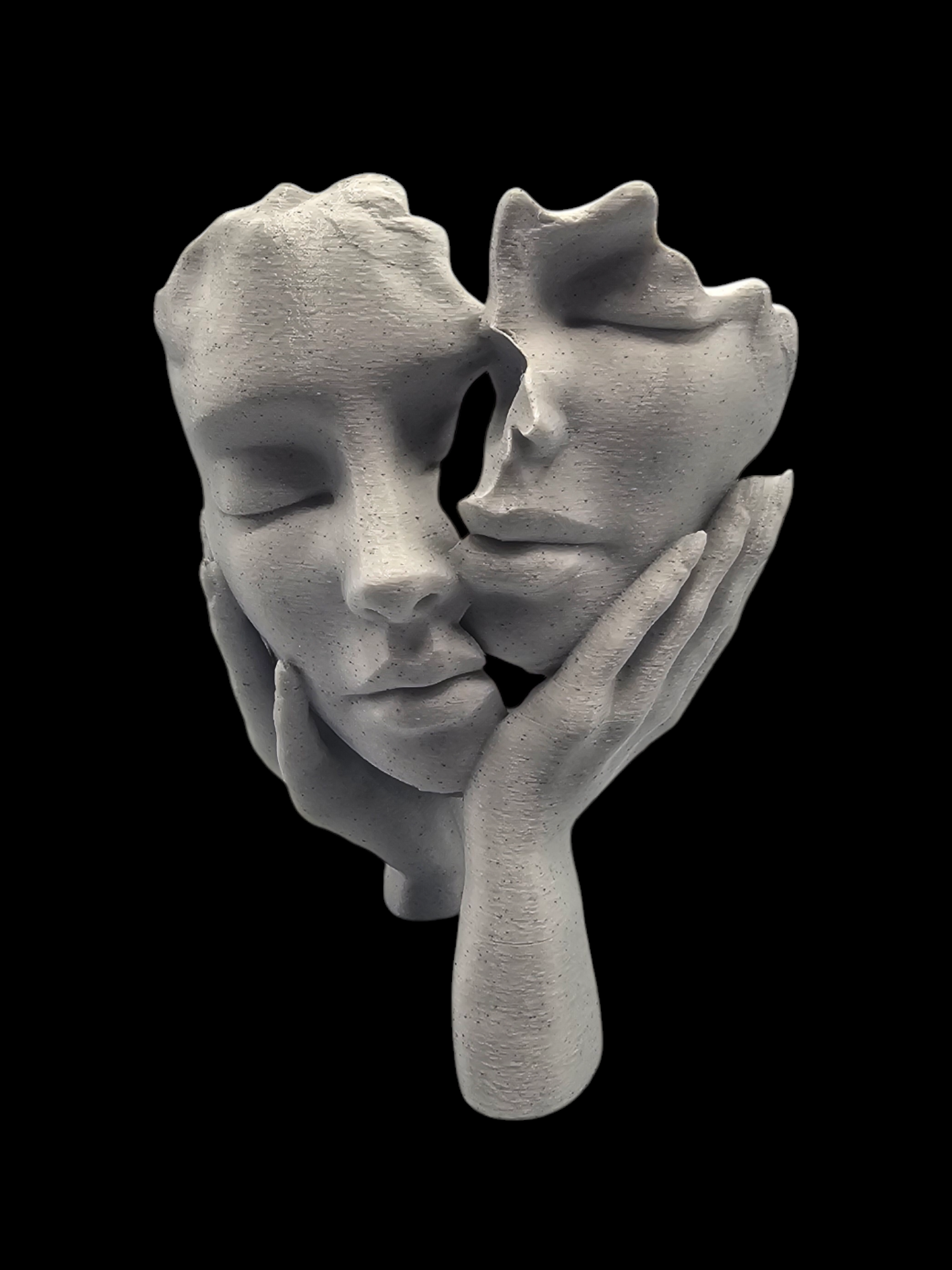 Beeldhouwwerk van twee gezichten die bij de lippen met elkaar verbonden zijn, waarbij het ene gezicht het andere gezicht vasthoudt; lichtgrijs op zwart.