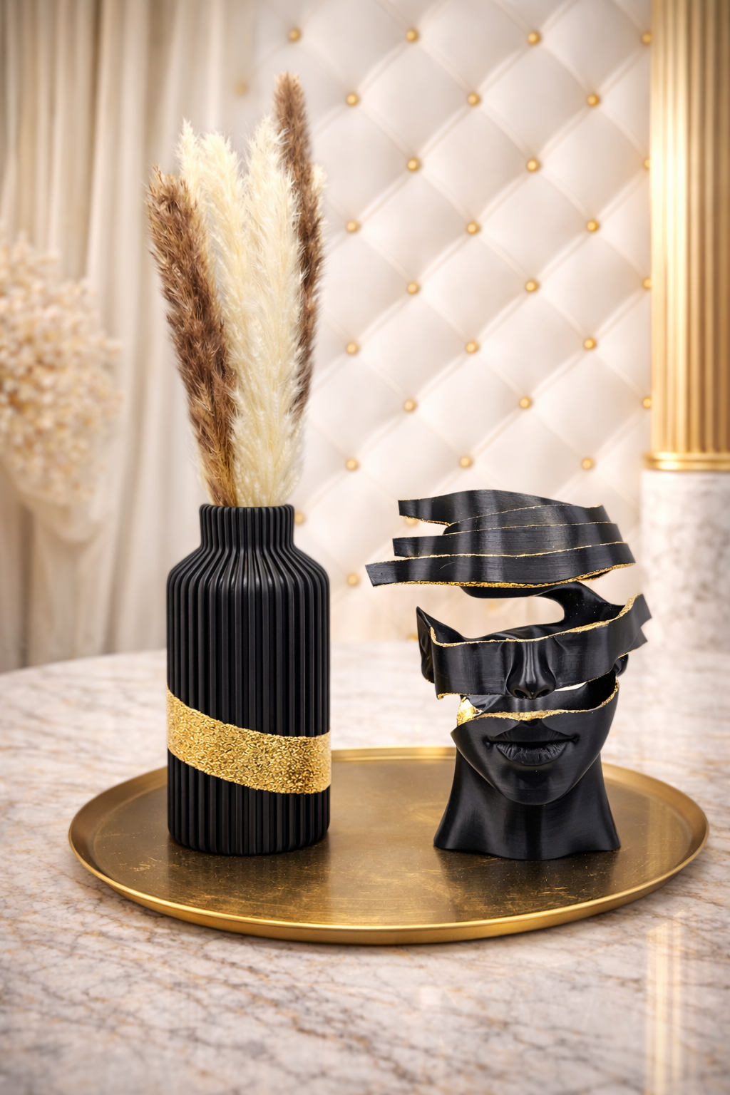 Zwarte vaas met gouden rand en pampasgras, zwart abstract gezichtsbeeldje op gouden dienblad.