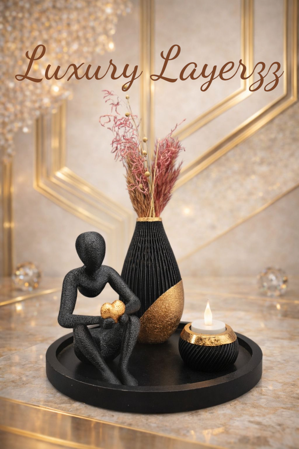 Luxe decoratie: zwart beeld, vaas met roze bloemen, kaars en dienblad op een marmeren ondergrond.