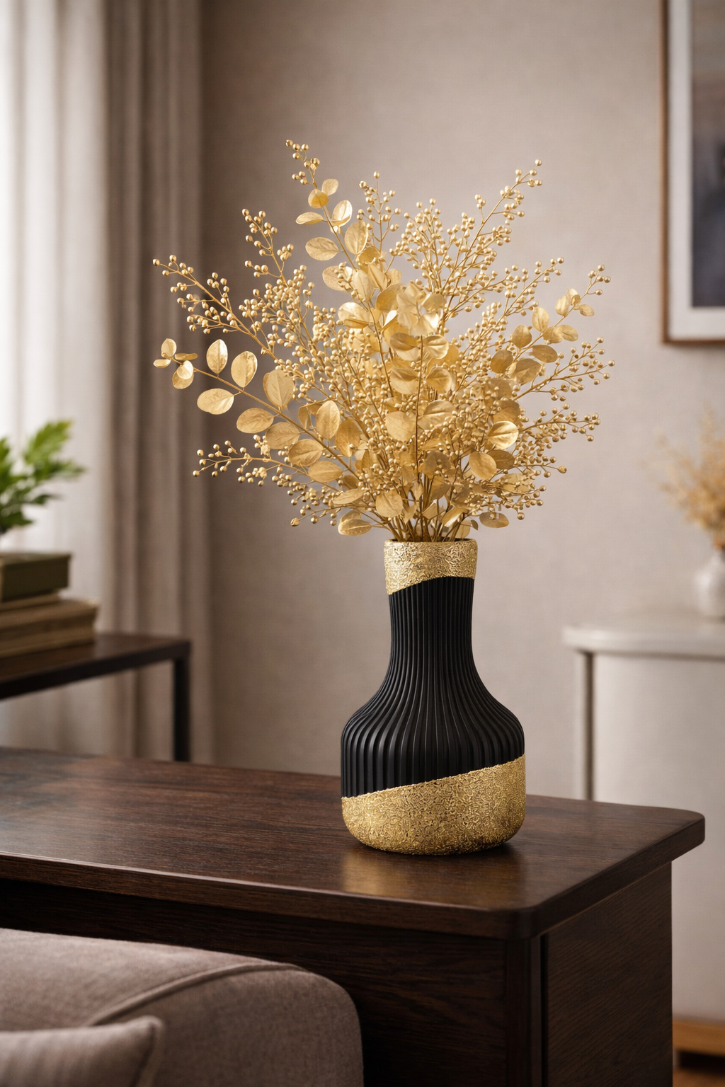 Gouden bloemstuk in een zwart-gouden vaas op een donkere houten tafel.