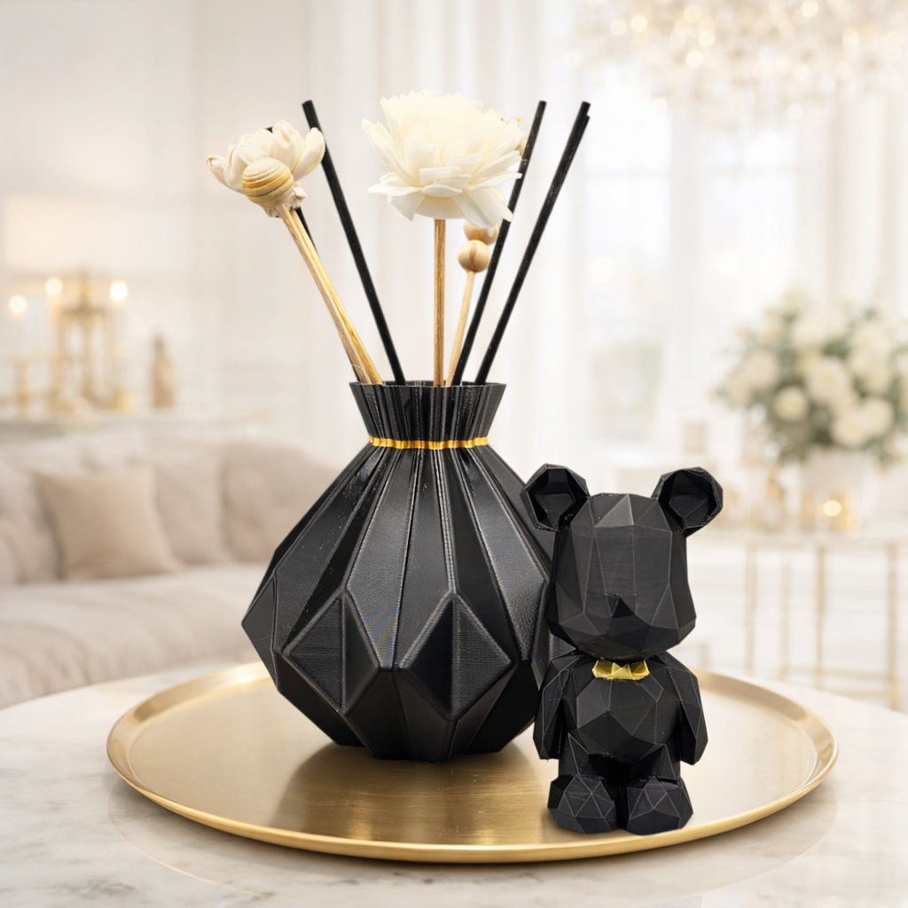 Zwarte geometrische vaas met rietstengels en een berenfiguurtje op een gouden schaal, in de woonkamer.